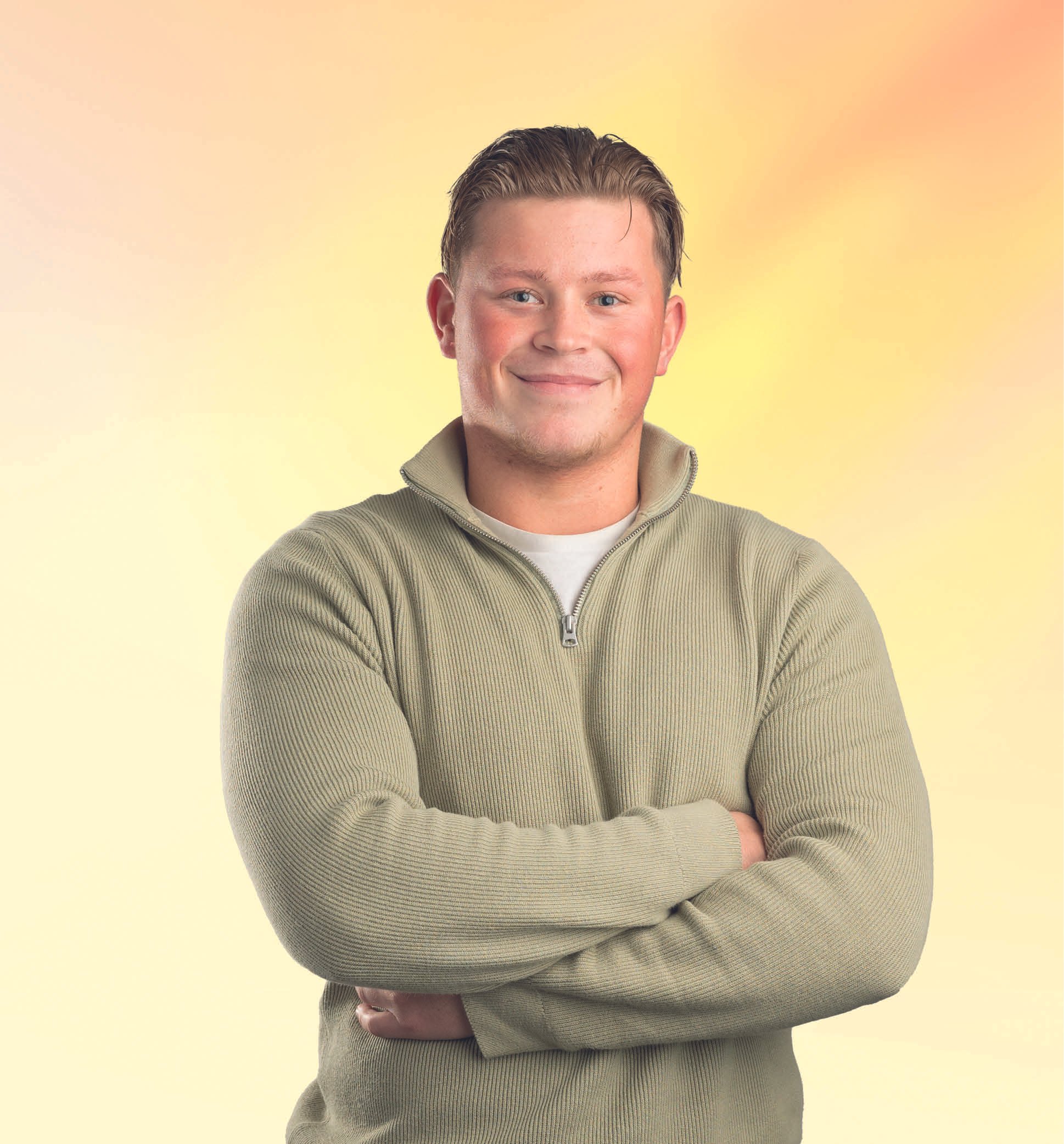 Man lacht en staat met gekruiste armen voor een gele achtergrond.