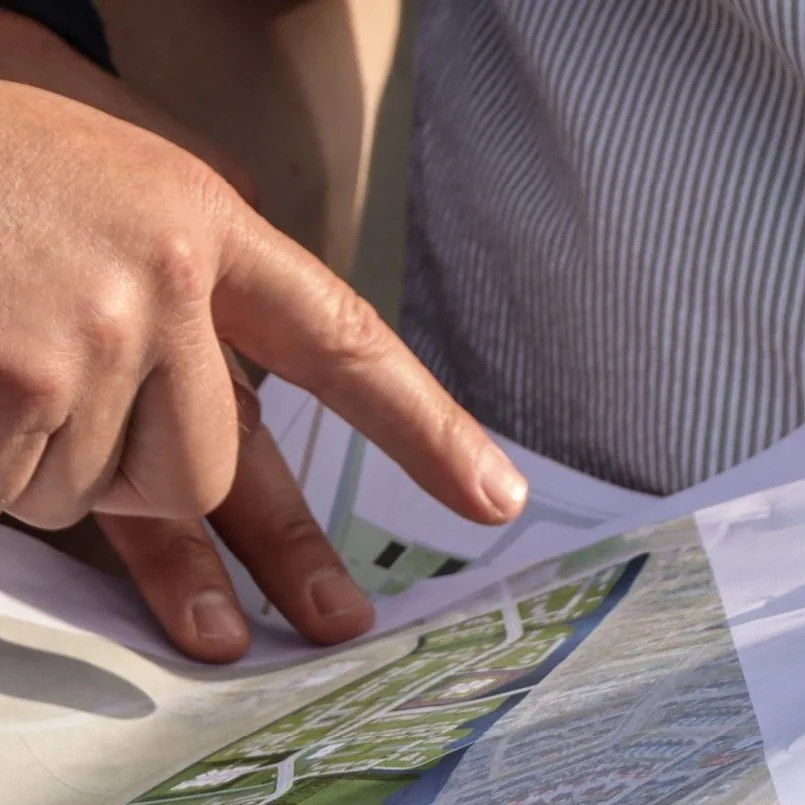 Een hand die met de wijsvinger op een plattegrond of kaart wijst.