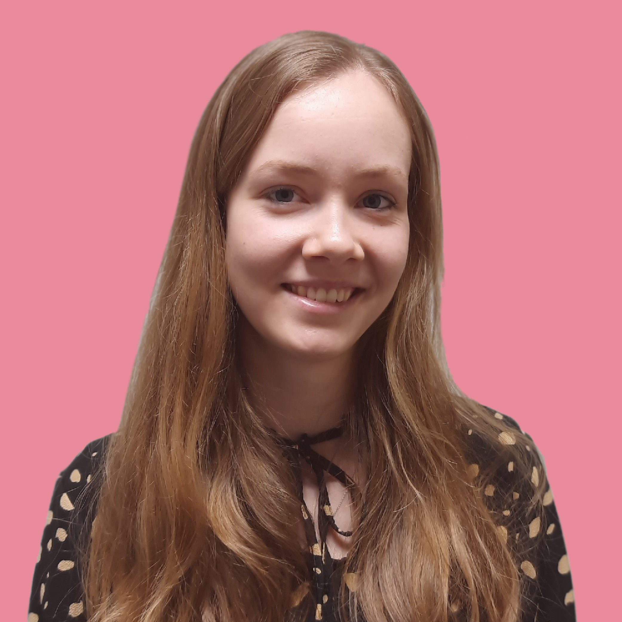 Portret van een jonge vrouw met lange, golvende, lichtbruine haar, lachend, tegen een roze achtergrond, gekleed in een zwarte blouse met beige stippen en een zwarte strik.