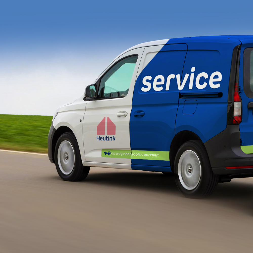 Een blauwe en witte dienstwagen rijdt op een weg in een groen landschap met een blauwe hemel.