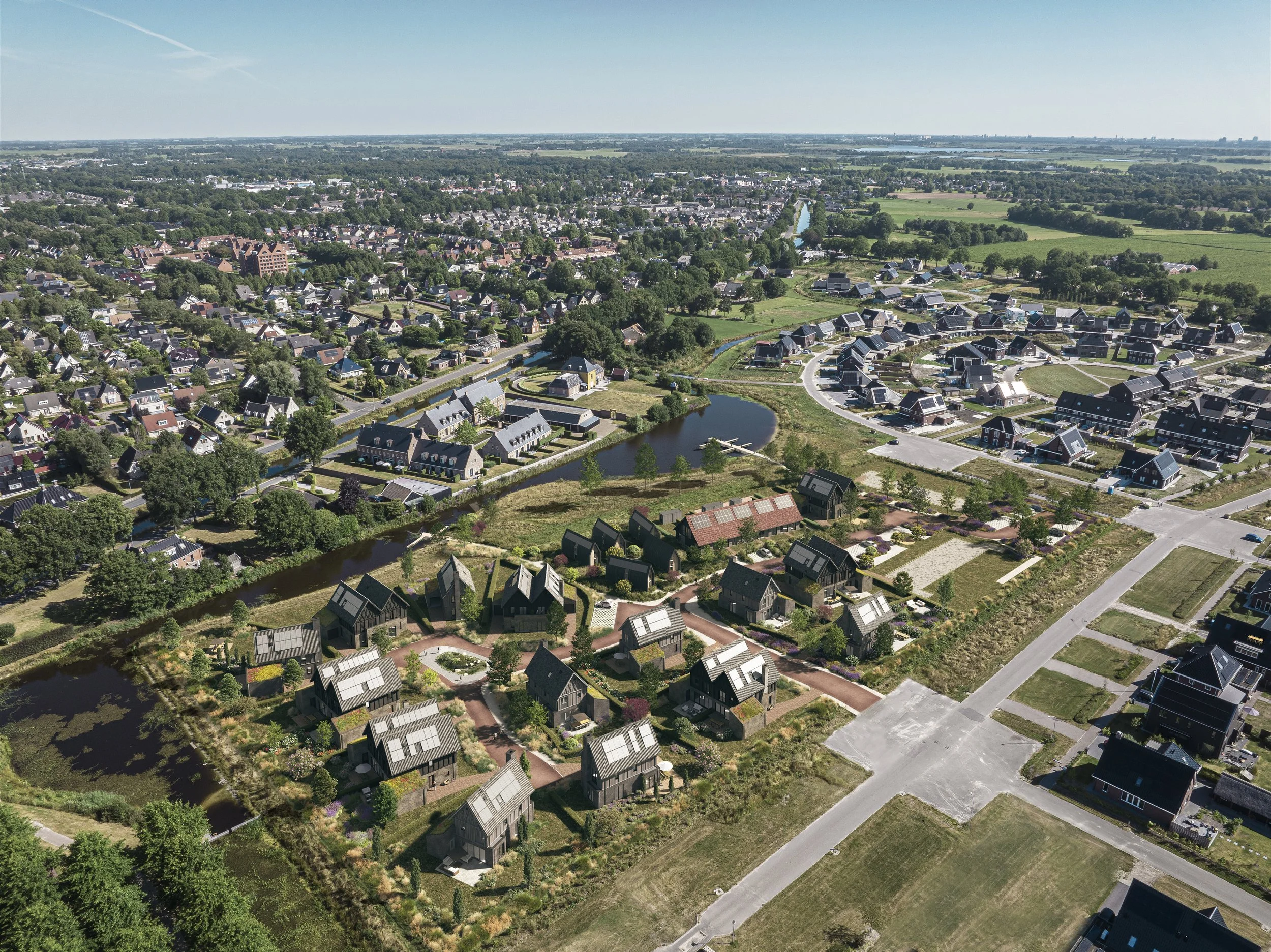 Luchtfoto van een moderne woonwijk met verschillende huizen, waterpartijen en groene gebieden.