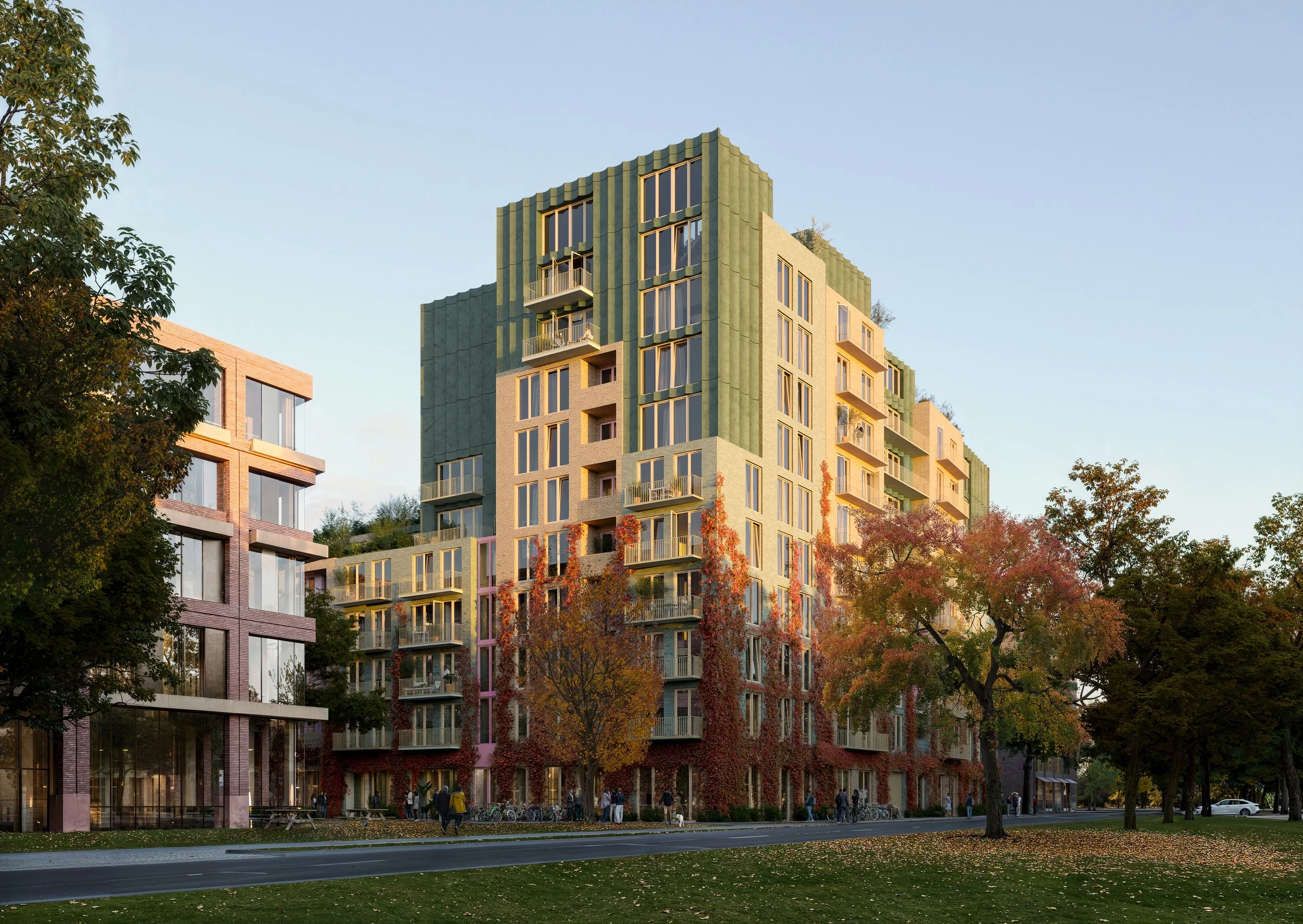 Moderne woongebouw met groene en beige gevels en balkons, omringd door herfstbomen op een straat in een parkachtige omgeving.