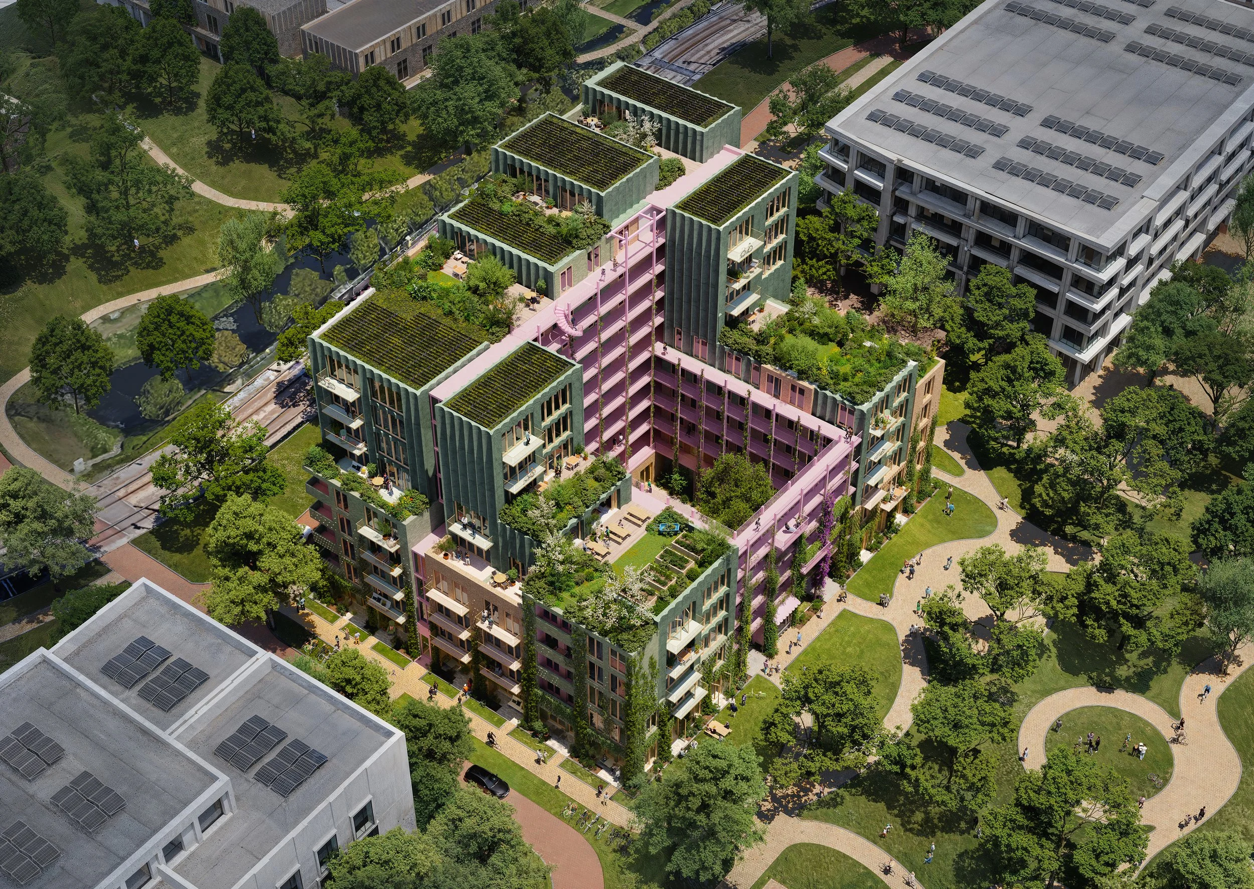 Een kleurrijk, modern appartementencomplex met groene daken, omgeven door een park met wandelpaden en veel groen, in een stedelijke omgeving.
