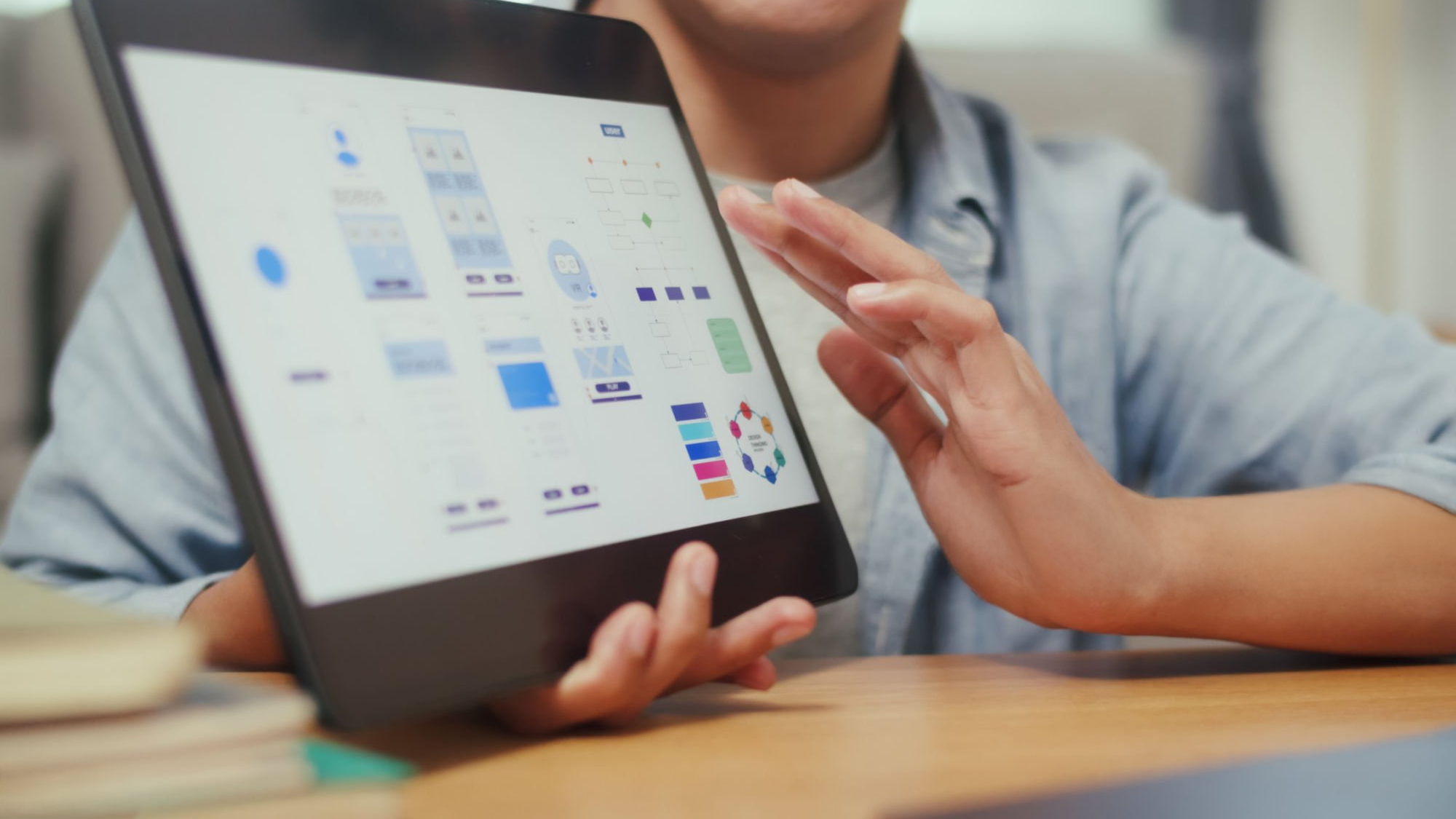Person holding a tablet displaying various colorful charts and graphs.