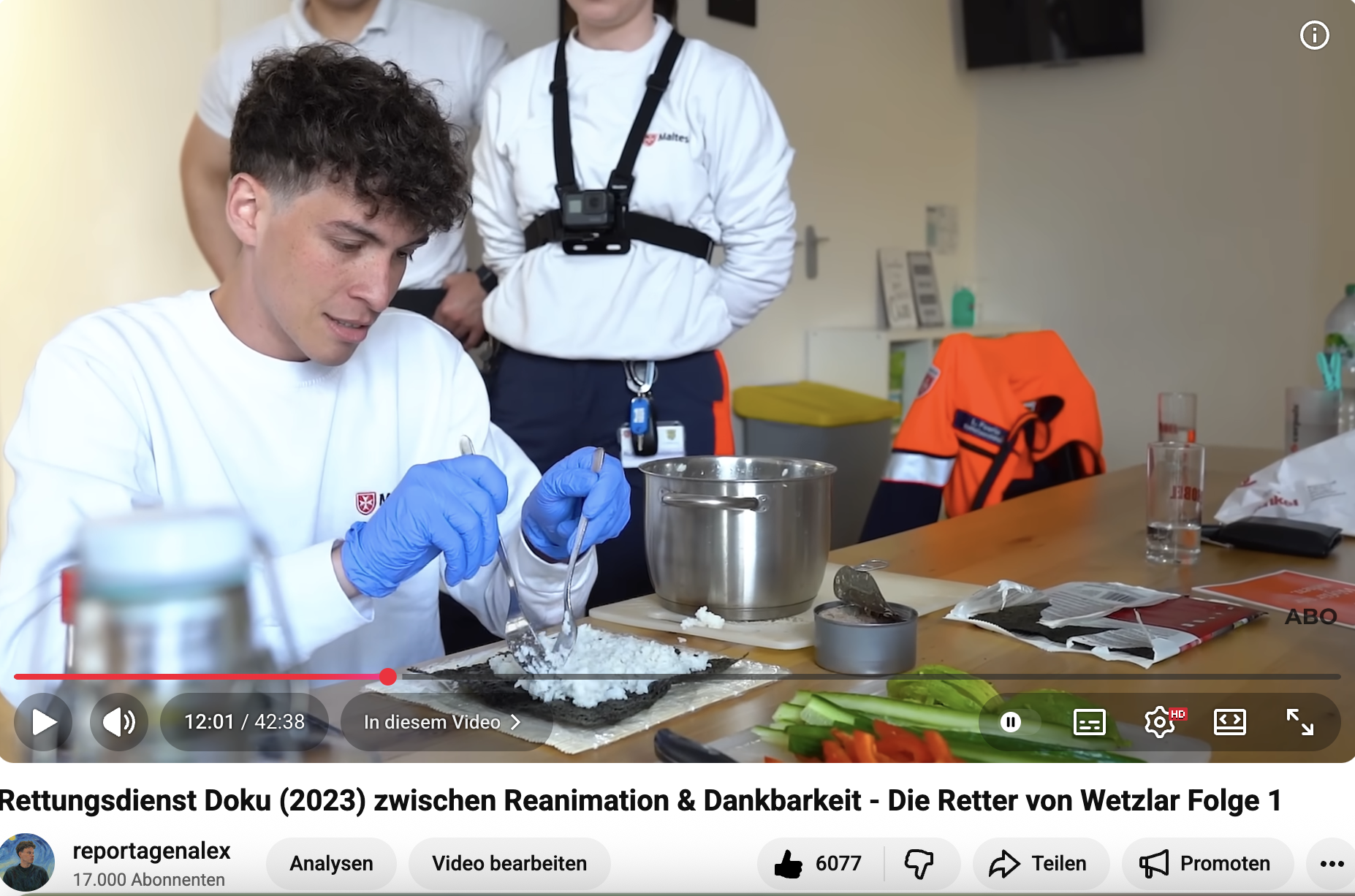 Sanitäter im Rettungsdienst bereitet Sushi zu. Kollegen stehen im Hintergrund.