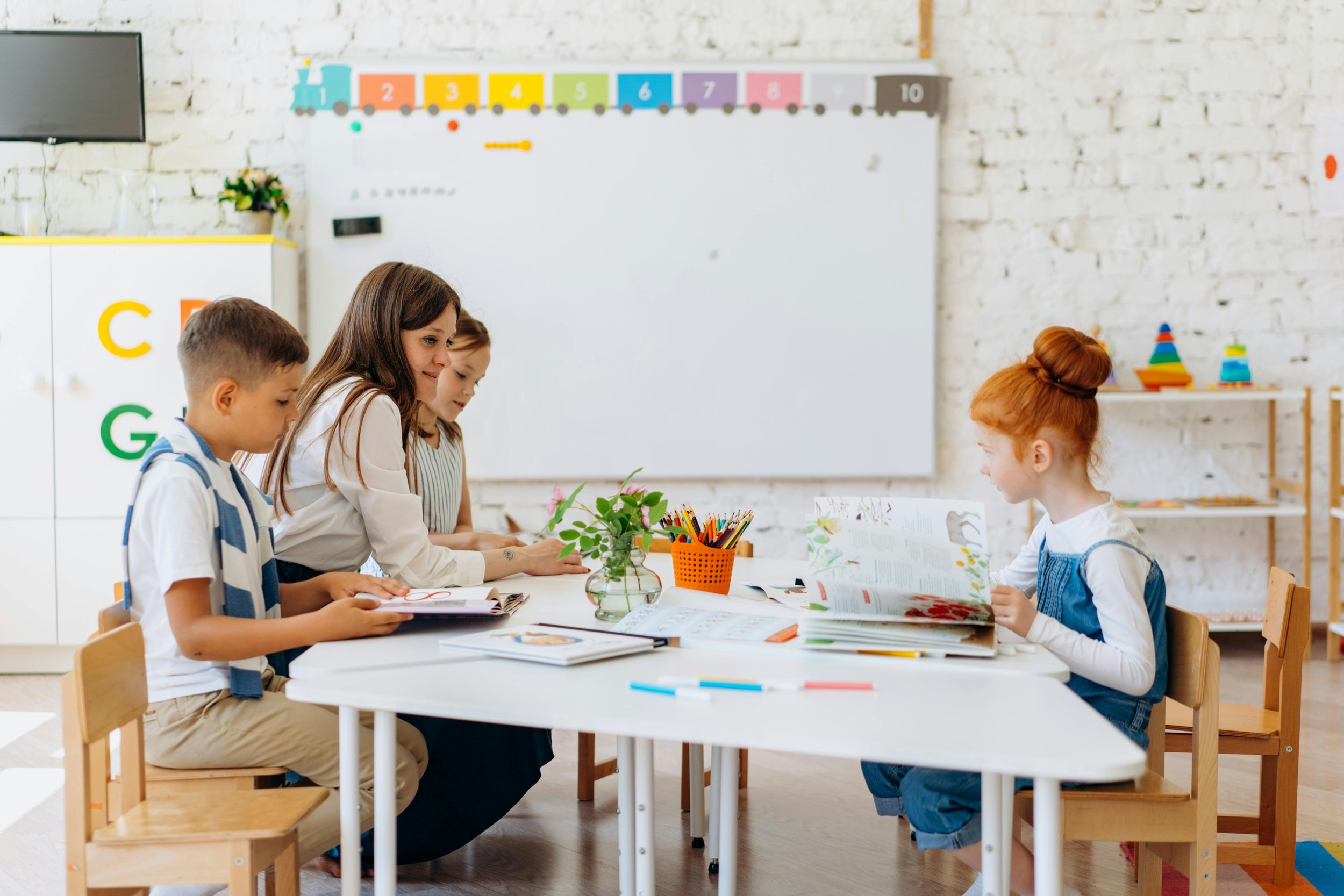 A teacher at a table with some children
