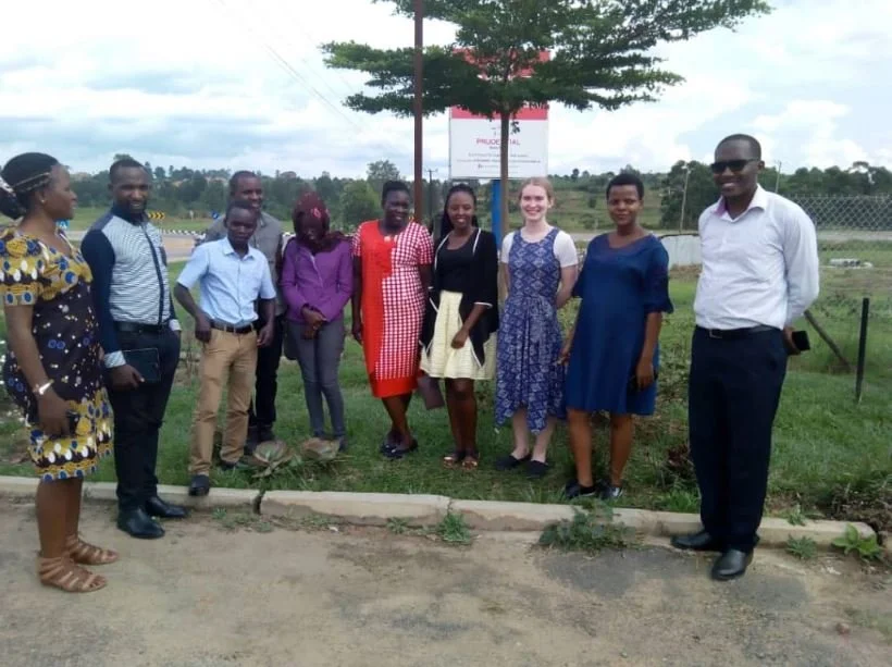 9 members of the CAMTech team stand in a line on a patch of grass. All are smiling at the camera.