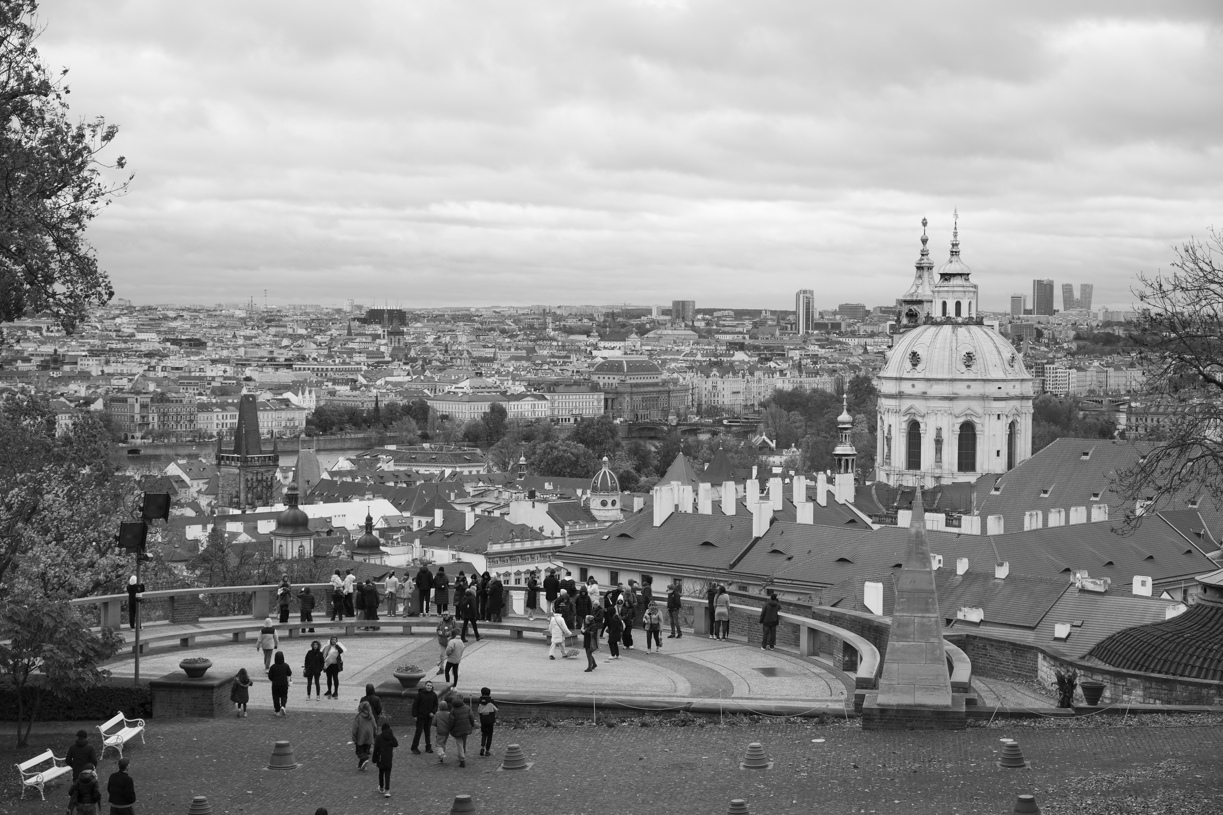 丘の上の展望台から見た、教会のドームと都市の風景。人々が散策している様子も見える。