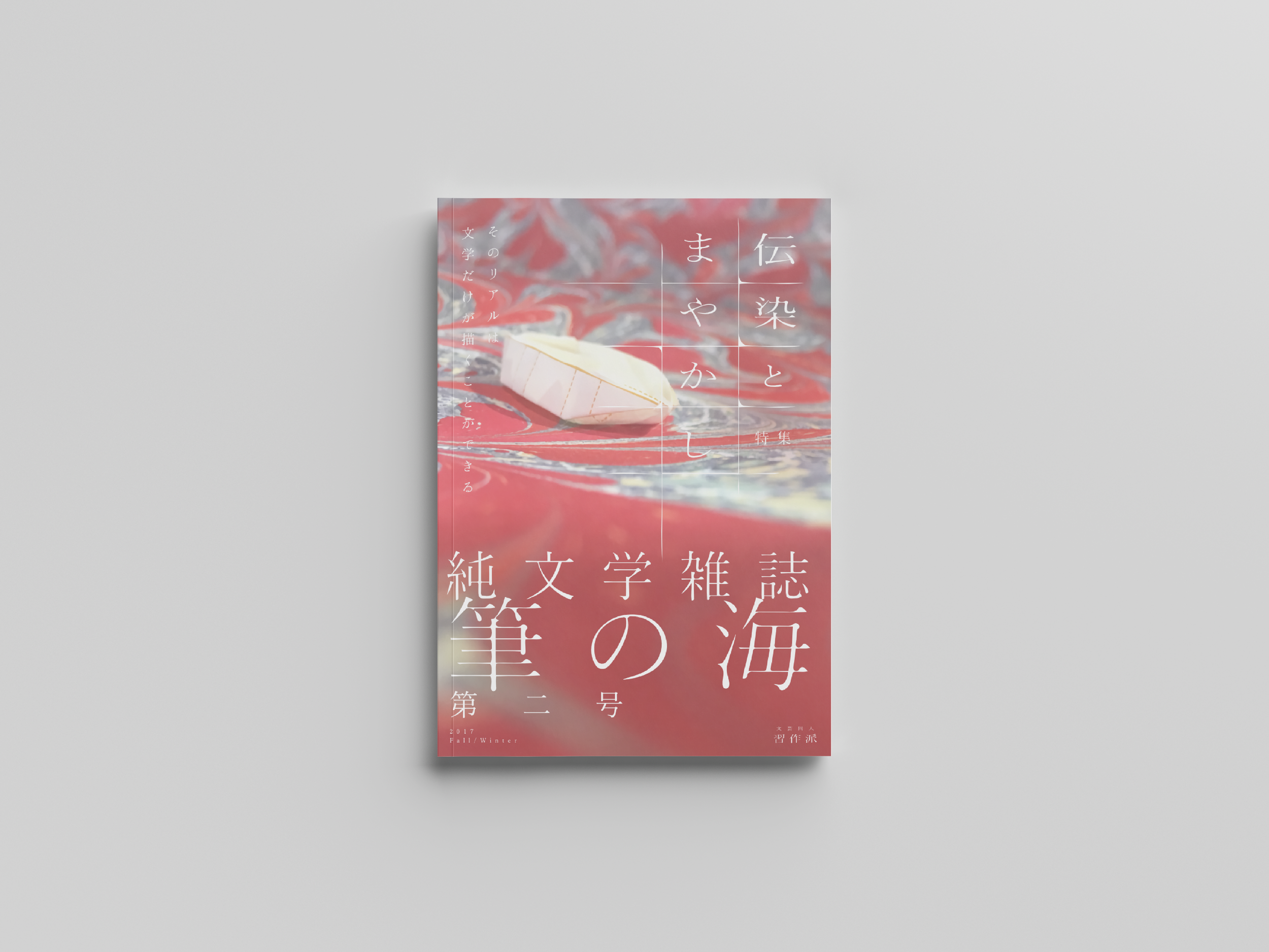 赤い海の模様と白い紙の舟の写真。