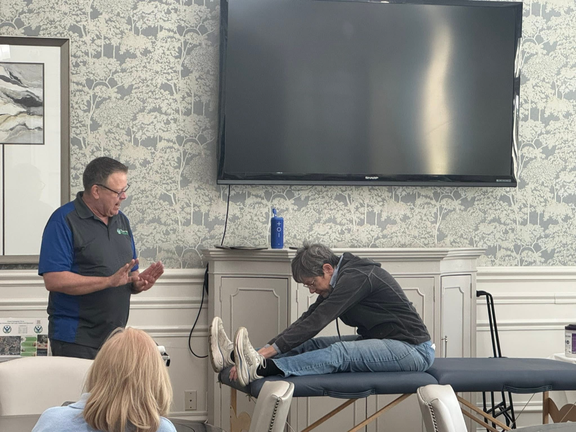 Licensed massage therapist demonstrating treatment during a wellness session