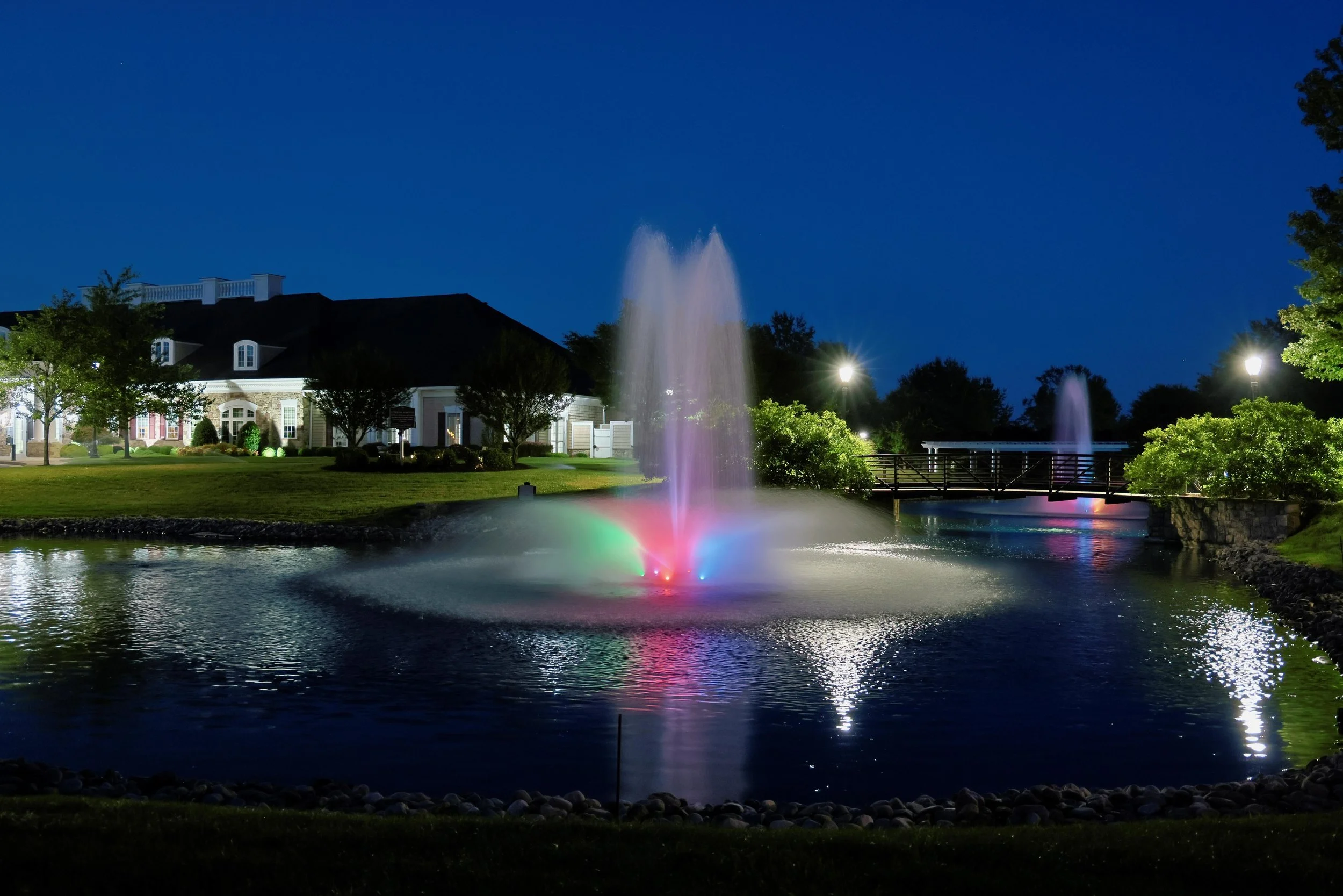 Clubhouse and illuminated pond at night