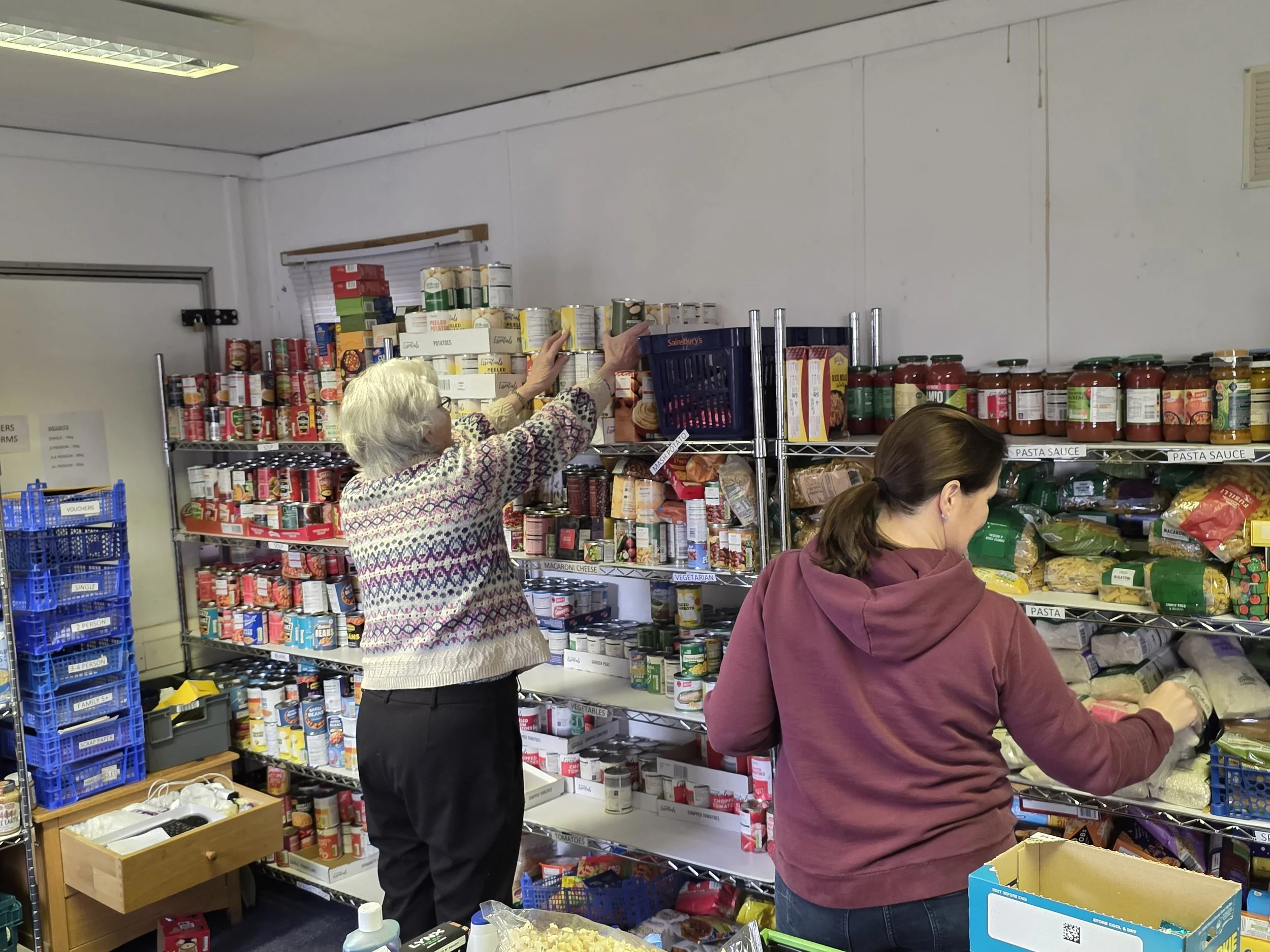Two of our volunteers working in the foodbank headquarters in Kettering