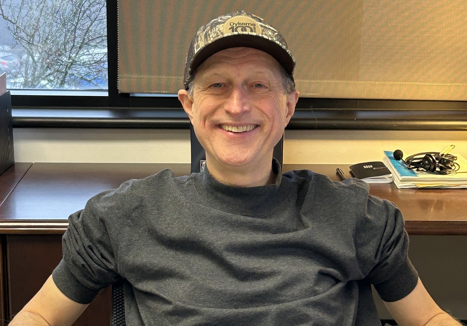 Dykema staff showcasing the Dykema100 hat during the teams centennial kickoff event. 