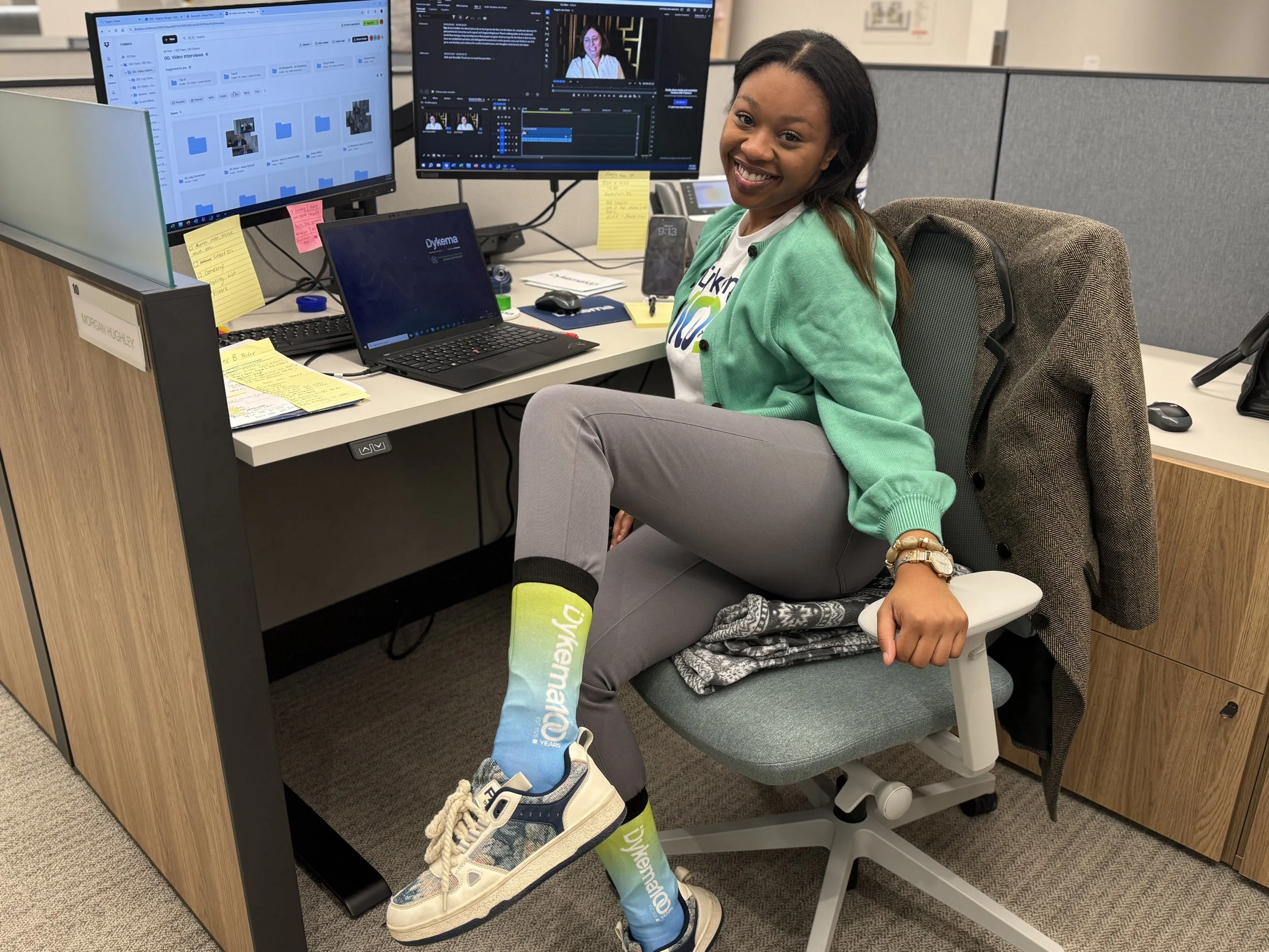 Morgan Hughley, Dykema marketing intern showing off her Dykema 100 swag in Dykema's Detroit office. 