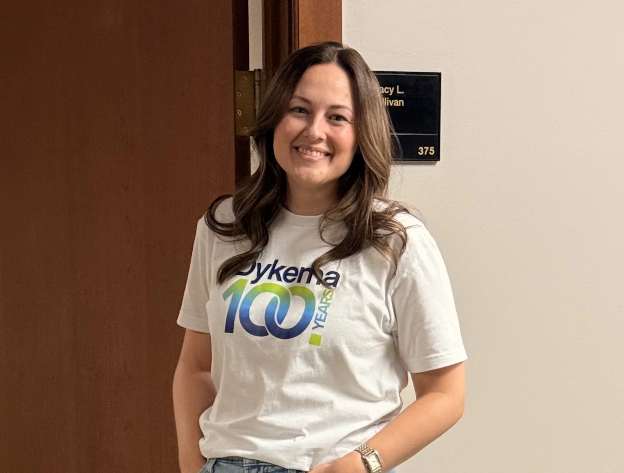 Dykema staff showing off the Dykema100 t-shirt during the firms centennial kickoff event.  