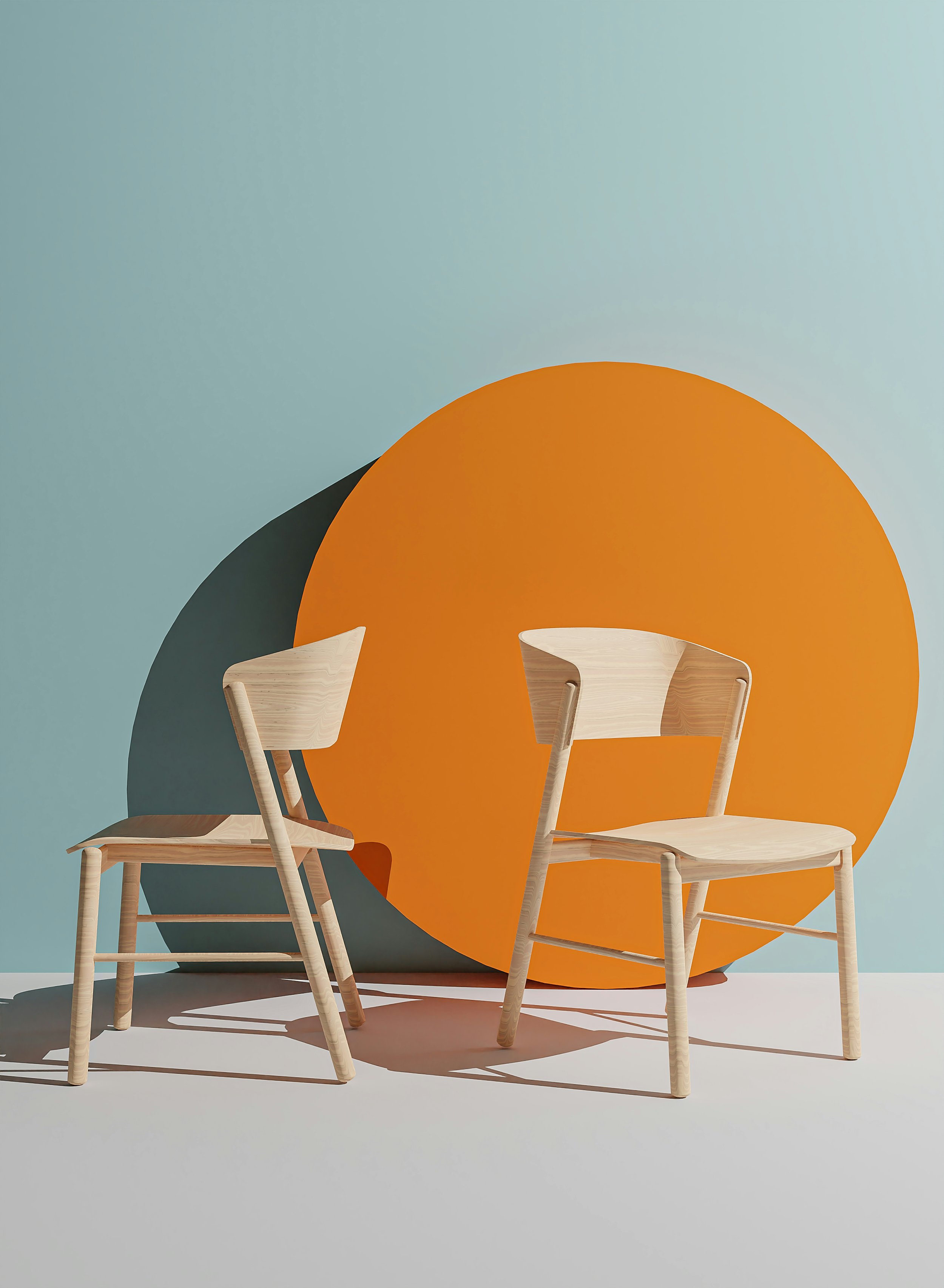 Two wooden chairs in front of a large orange circle and a smaller dark gray circle on a pastel wall.