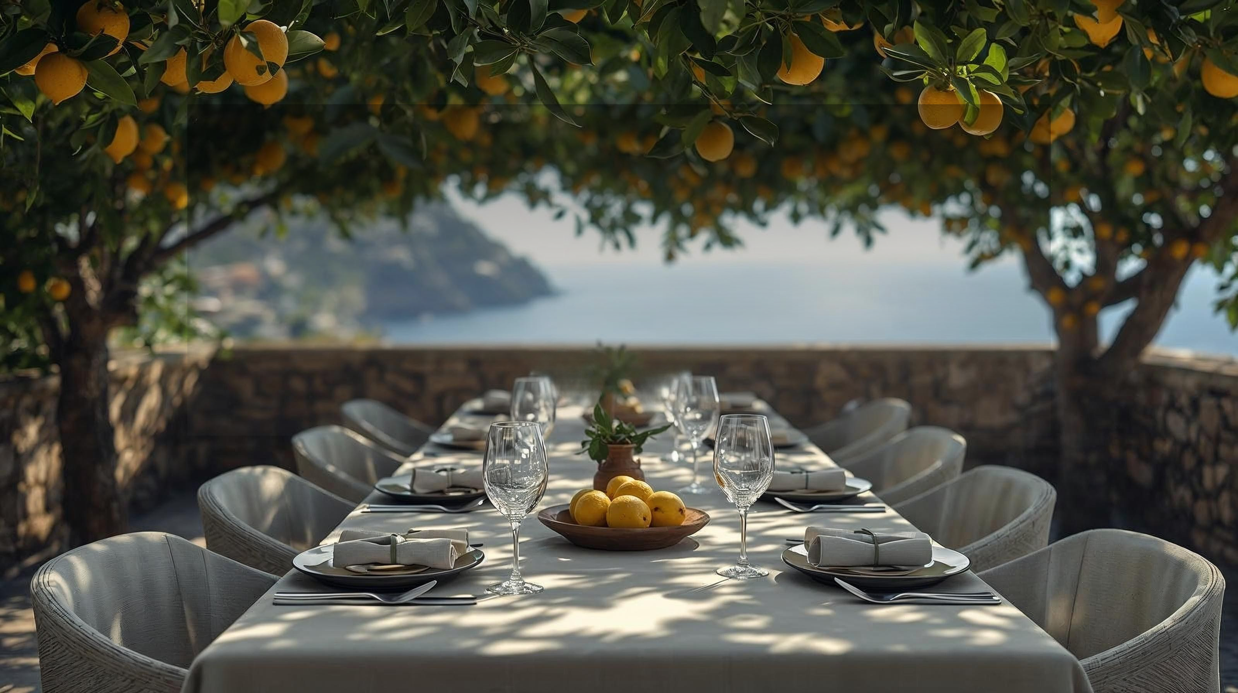 Outdoor dining table set under lemon trees overlooking the amalfi coast