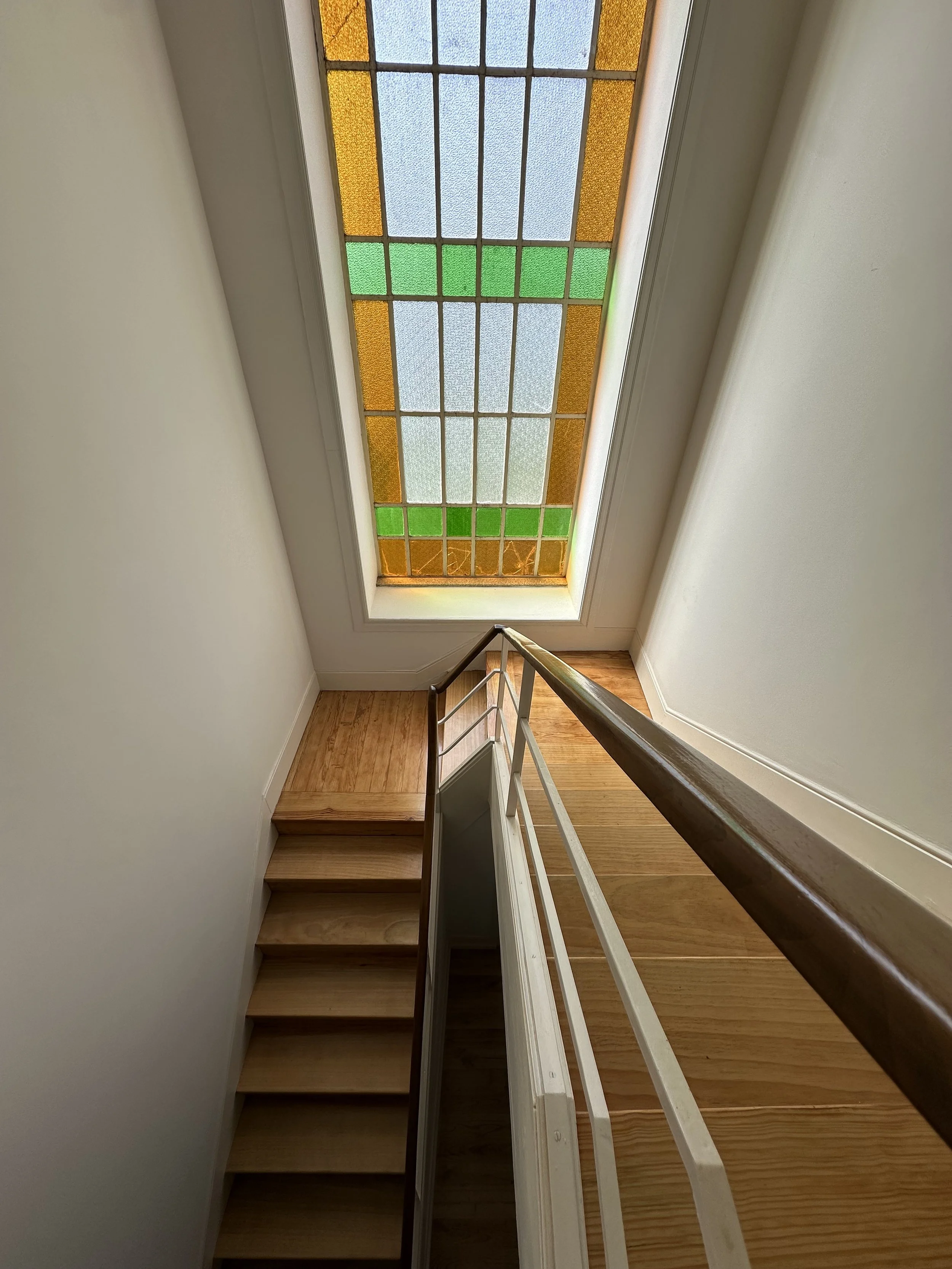 Close-up view of the stained glass window above the stairwell at Casa Belo Horizonte.
