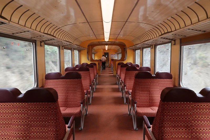 Interior of a Douro Train Line carriage with seating and large windows for scenic rail journeys.