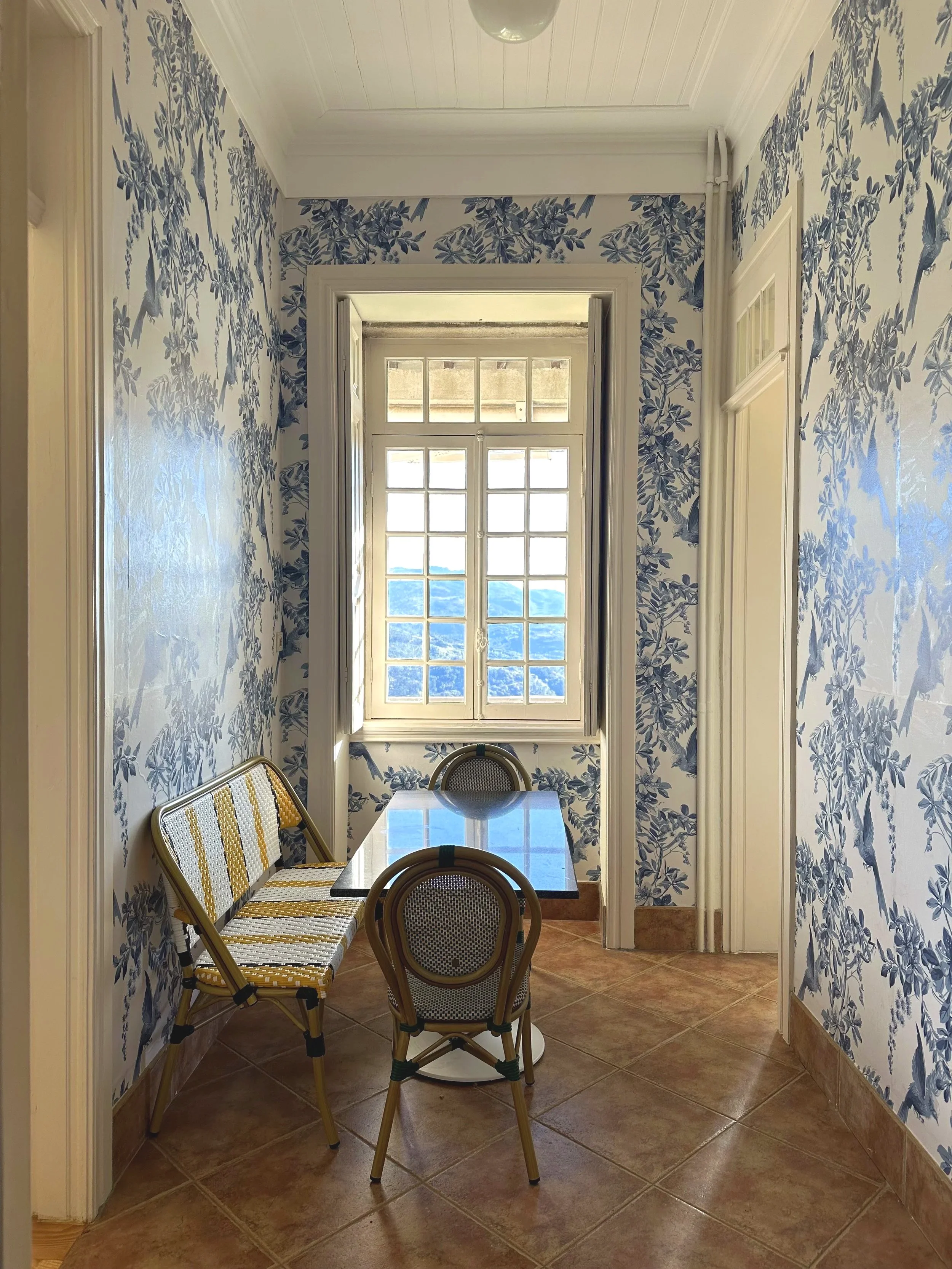 Breakfast room at Casa Belo Horizonte with a small dining table, natural light, and views toward the river.