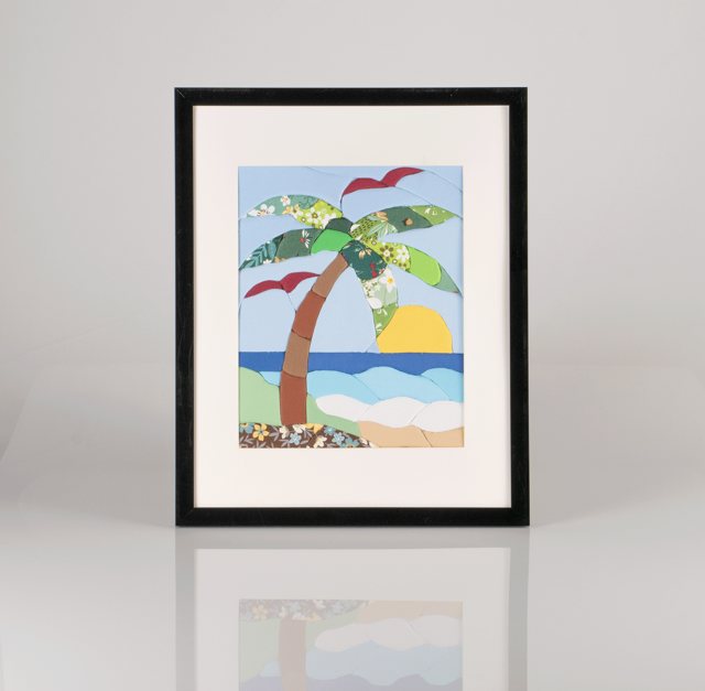Colorful fabric art of a palm tree on a beach with ocean, sunset, and seagulls in the background.