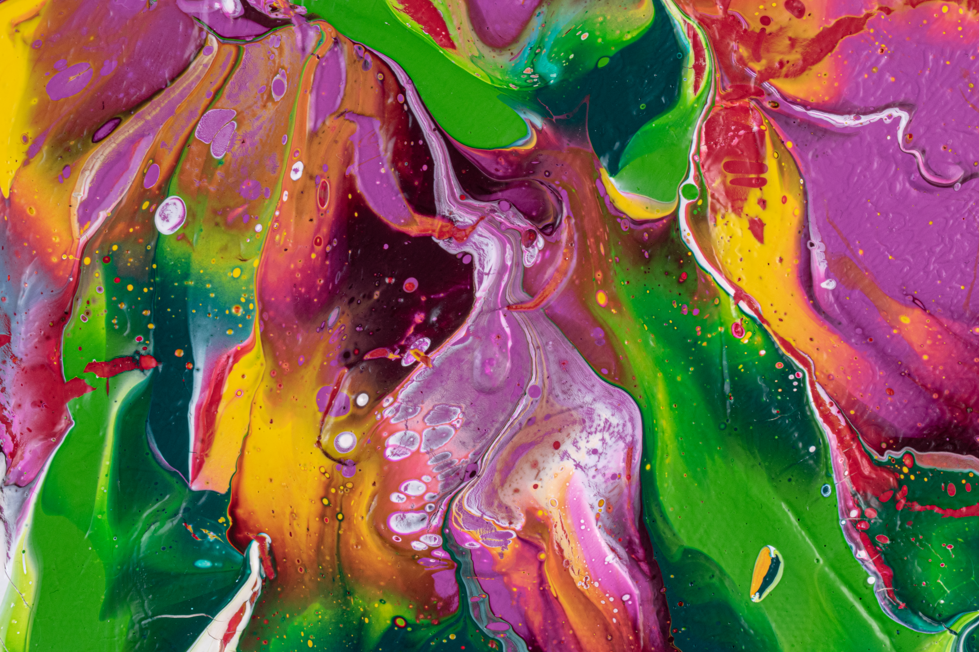 Abstract colorful paint splash with shades of pink, purple, green, yellow, red, and black blending and swirling together.