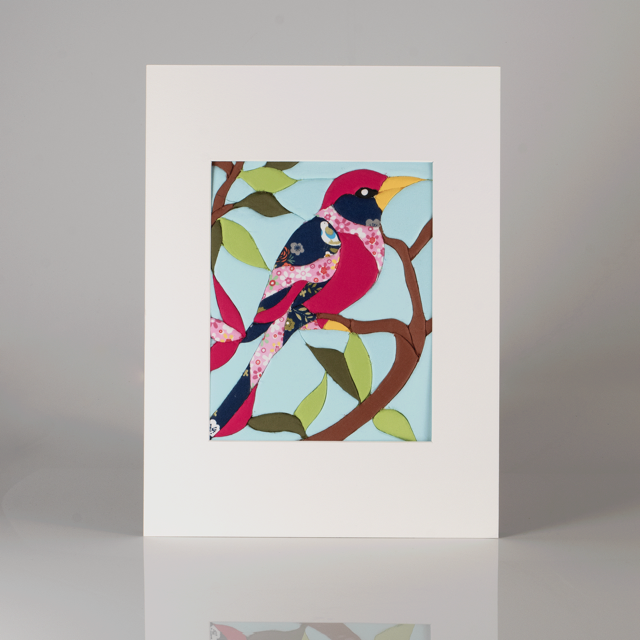 Colorful fabric art of two stylized birds perched on a branch