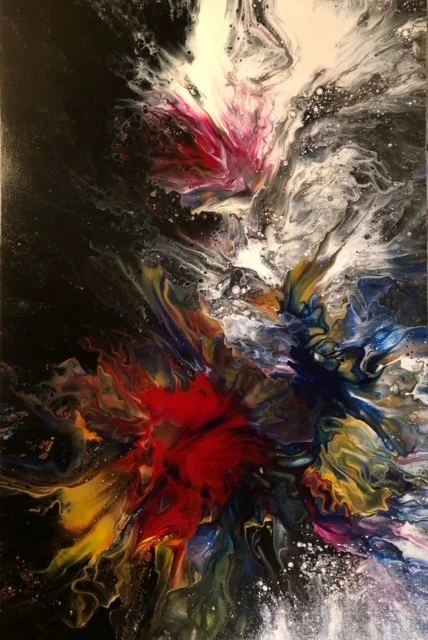 Abstract explosion of multicolored paint, including white, pink, red, blue, yellow, and black, creating a dynamic swirl pattern.