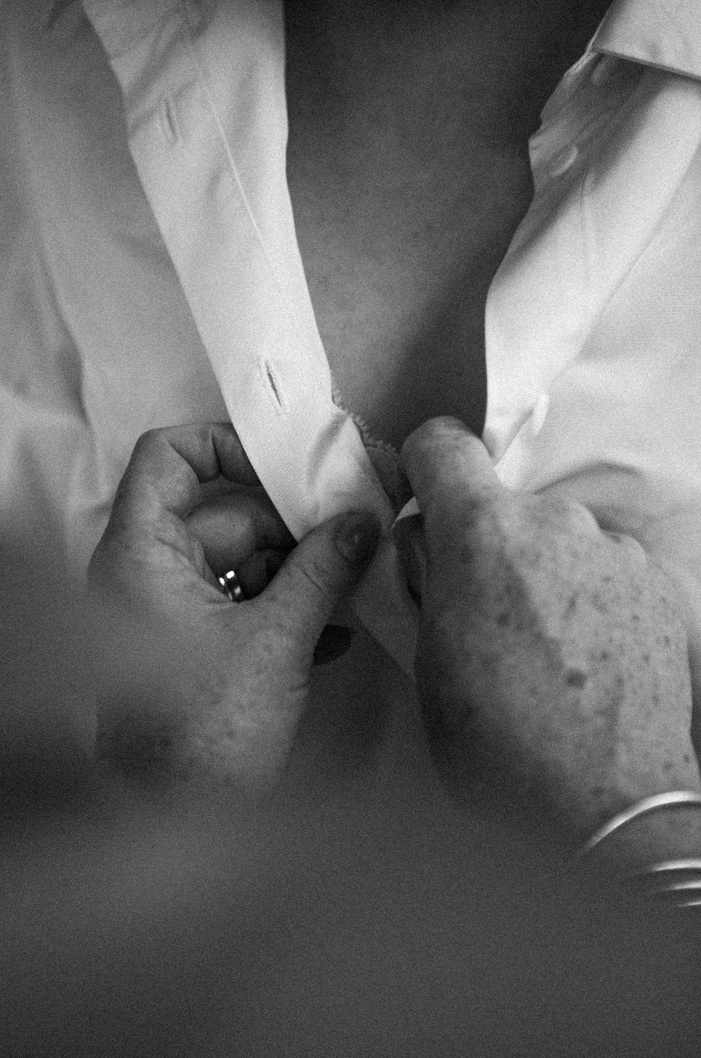 Mains âgées tenant un tissu blanc, photo en noir et blanc.