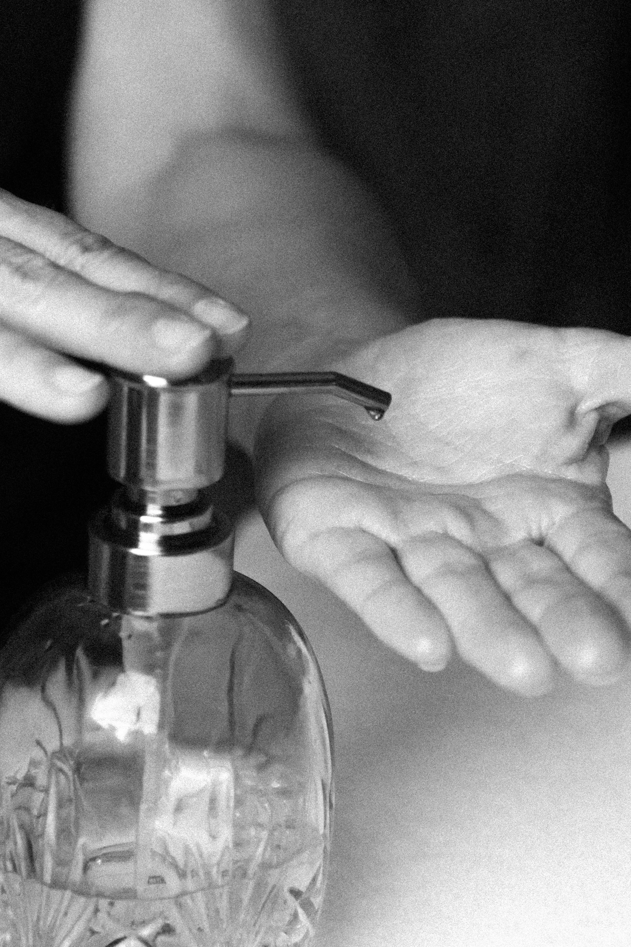 Main tenant du corps d'une personne utilisant un distributeur de gel désinfectant.