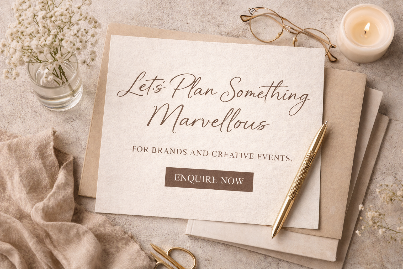 A promotional image with a beige background and elegant items including a glass vase with white flowers, a lit white candle, a pair of gold-rimmed eyeglasses, a gold pen, and a stack of beige and white papers. The central message on the paper reads: 'Let's Plan Something Marvelous for Brands and Creative Events. Enquire Now.'