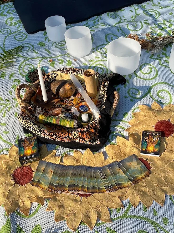 A decorated outdoor altar with candles, tarot cards, and spiritual objects on a sunflower-shaped cloth.