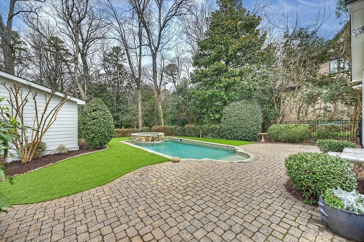 Private backyard with saltwater pool and raised spa, paver patio, turf lawn, and mature landscaping