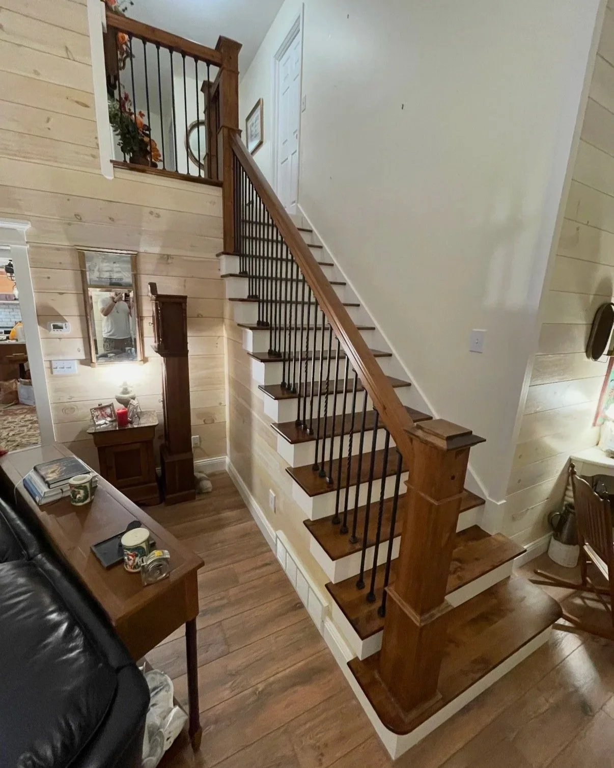 Completed staircase with stained treads, painted risers, and wood baluster railing.