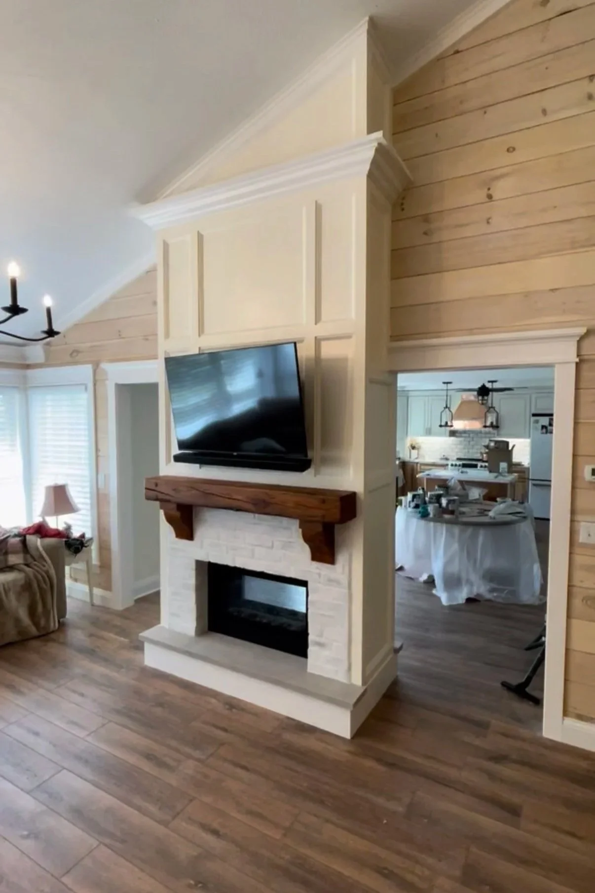 After: Finished feature wall with fireplace trim, reclaimed mantel, and TV mount above.