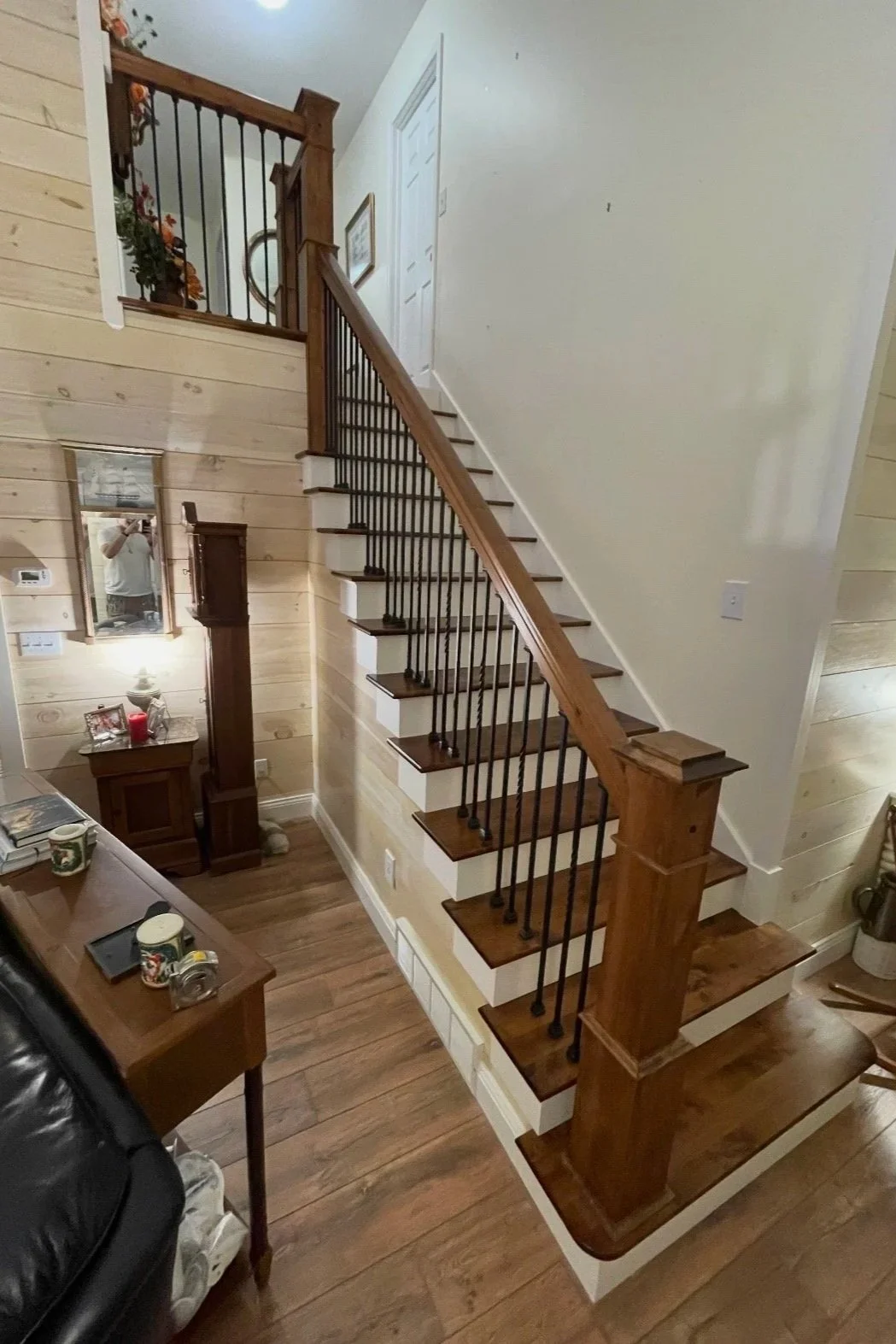 After: Completed staircase with stained treads, painted risers, and wood baluster railing.