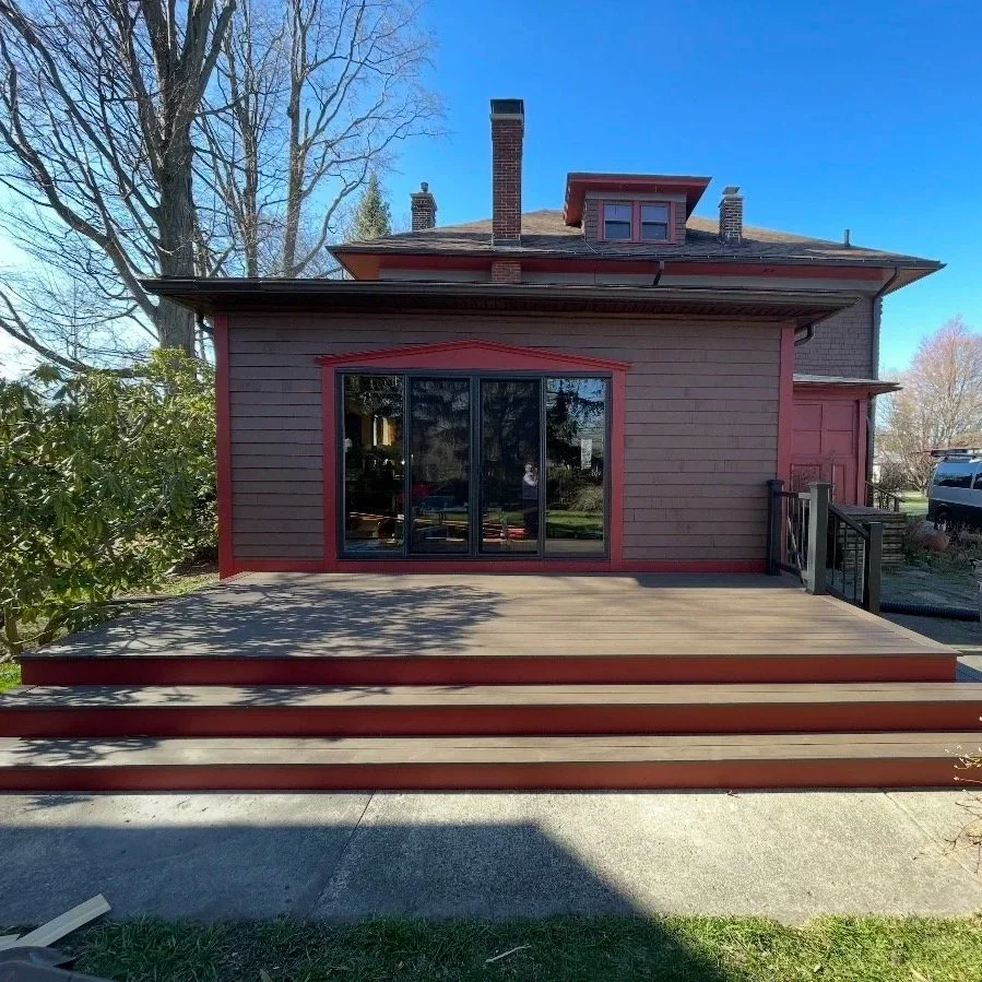 After: New sliding glass doors and composite deck with modern rail and steps.