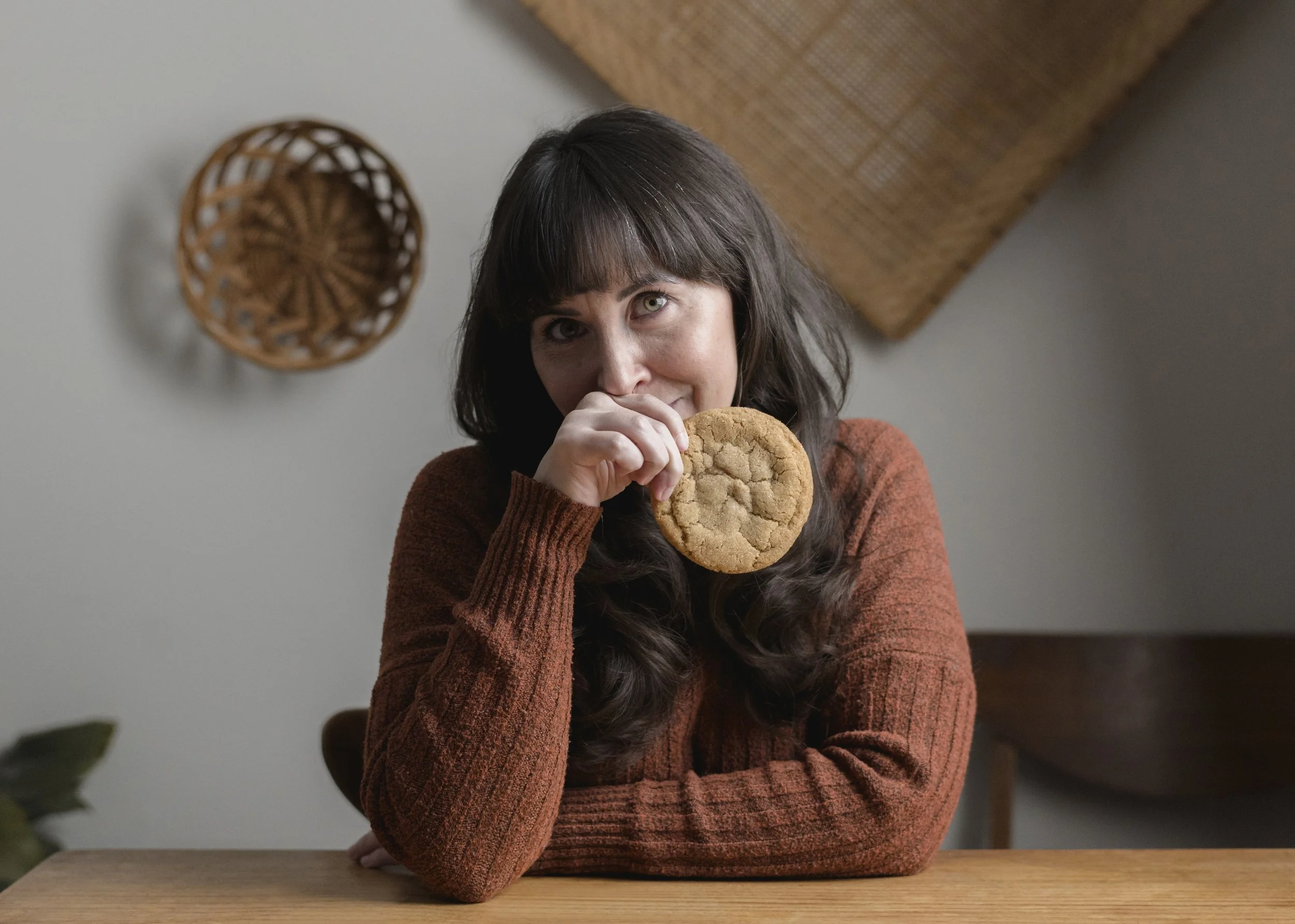 Ovhen baker with a cookie in her hand