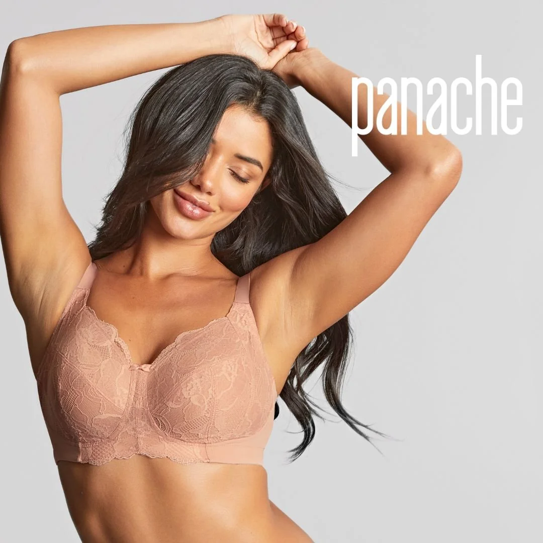 A woman with long dark hair and tan skin wearing a pink lace bralette, smiling with eyes closed, arms raised behind her head, against a light gray background with the word "panache" in white letters.