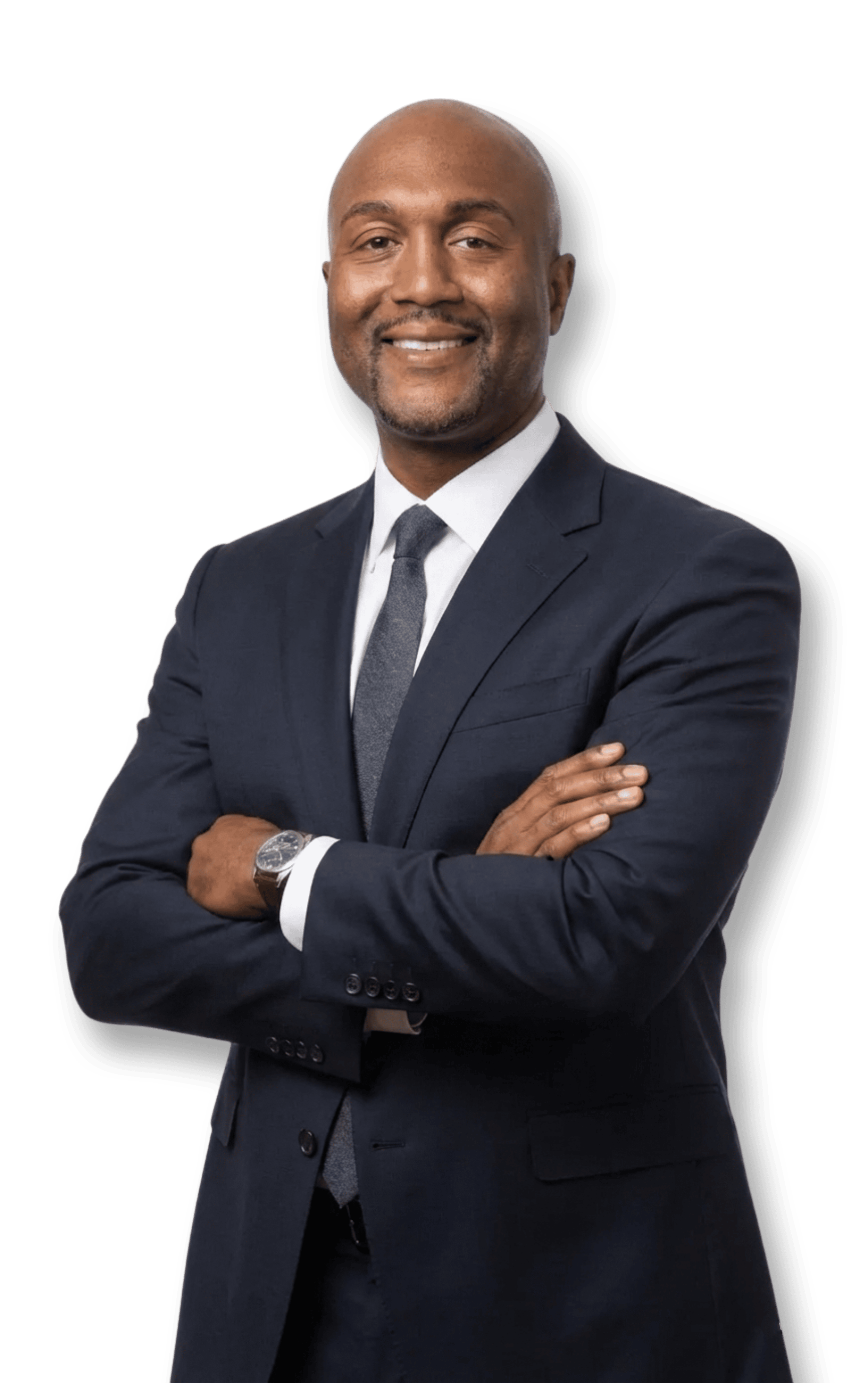 A confident African American man wearing a suit with his arms crossed, smiling, against a plain background.