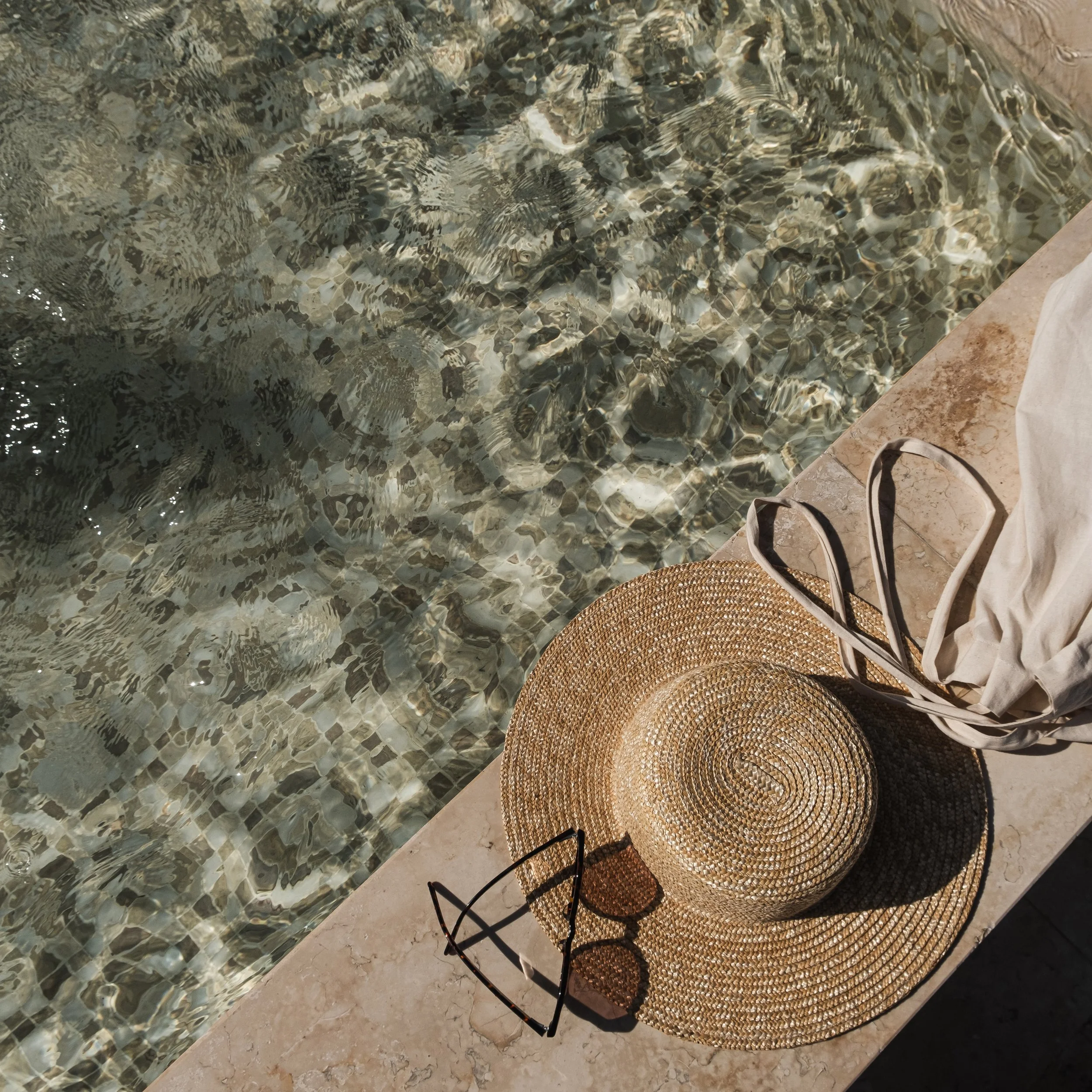 flat-lay-sunglasses-straw-hat-marble-swimming-pool-side-with-clear-blue-water-with-waves-sunlight-shadow-reflections (1).jpg