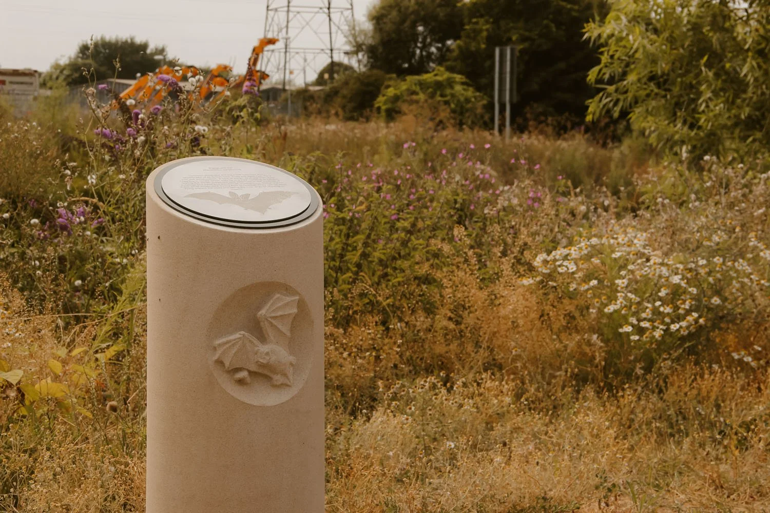 Carved stone column with a bat flying - part of the Arup Architects commission