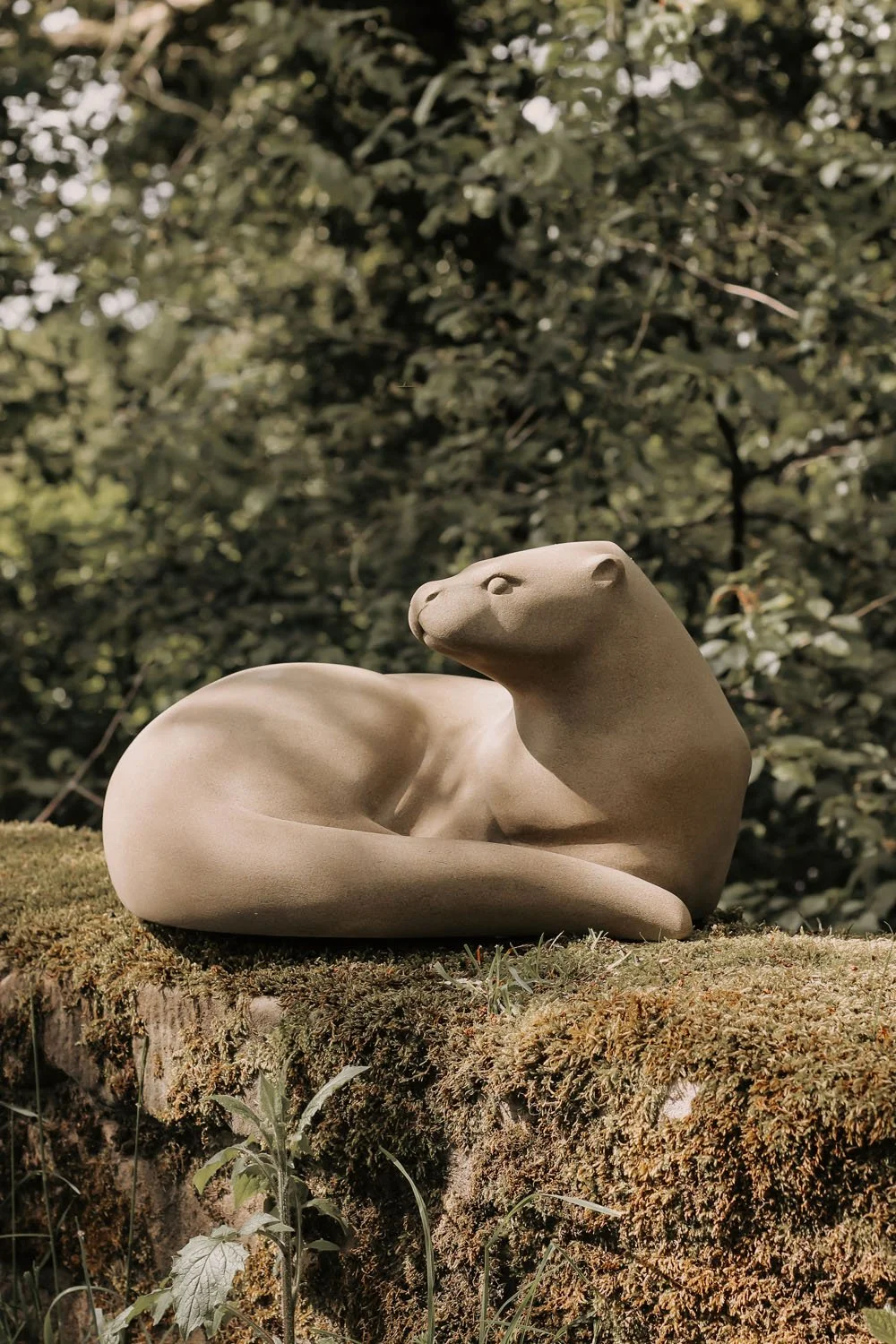 An Otter sculpture carved in sandstone for Hillsborough Castle and Gardens where it is placed on a rock in a ravine running with water