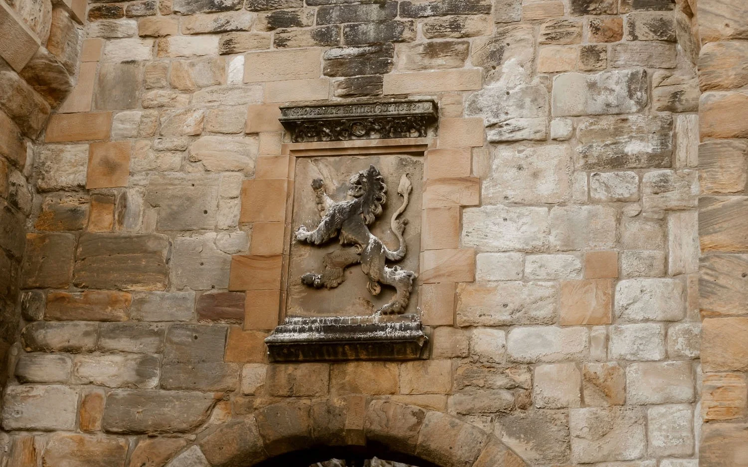 A stone carved lion plaque at the entrance to Alnwick Castle