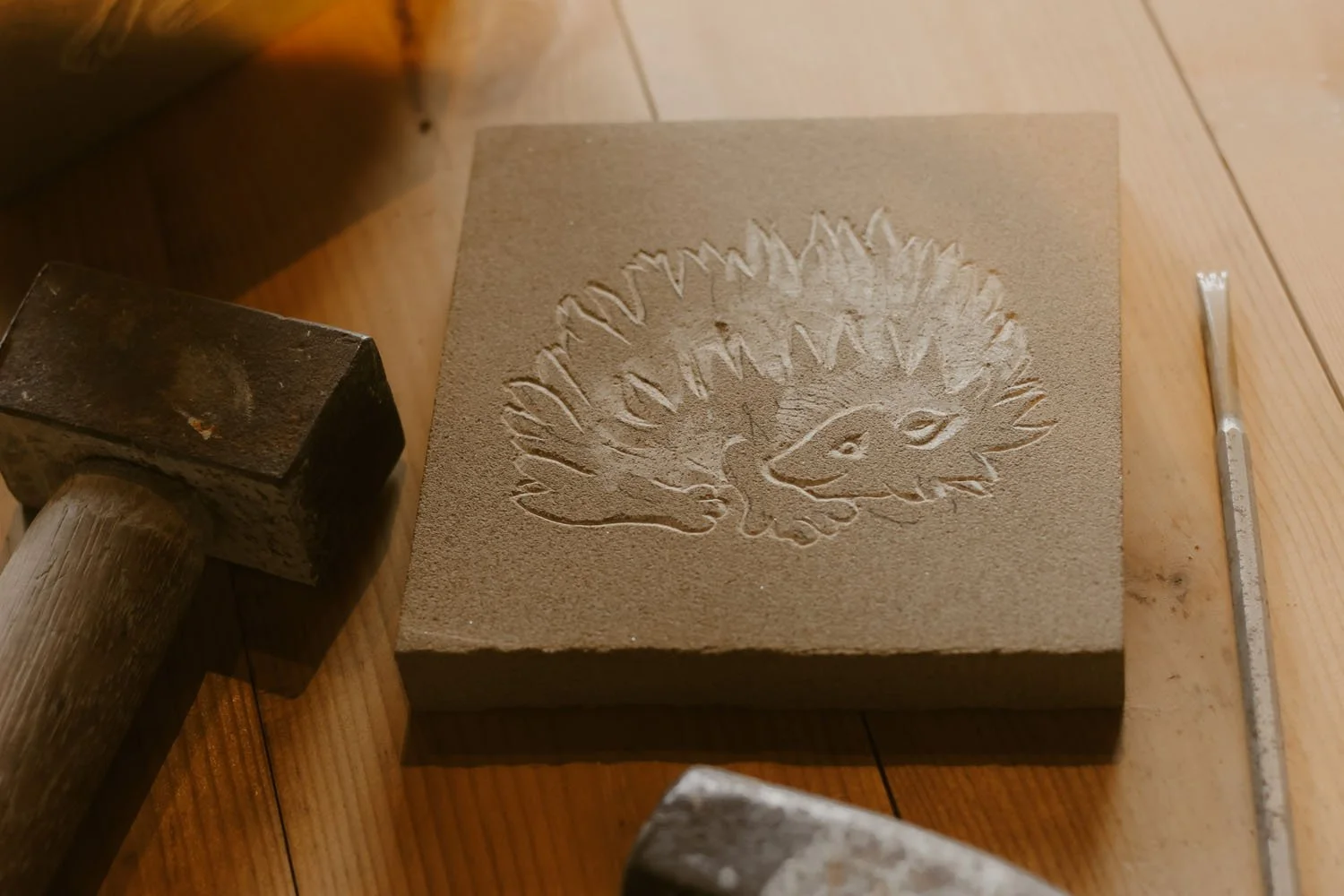 a medieval styled hedgehog carved on a stone tile