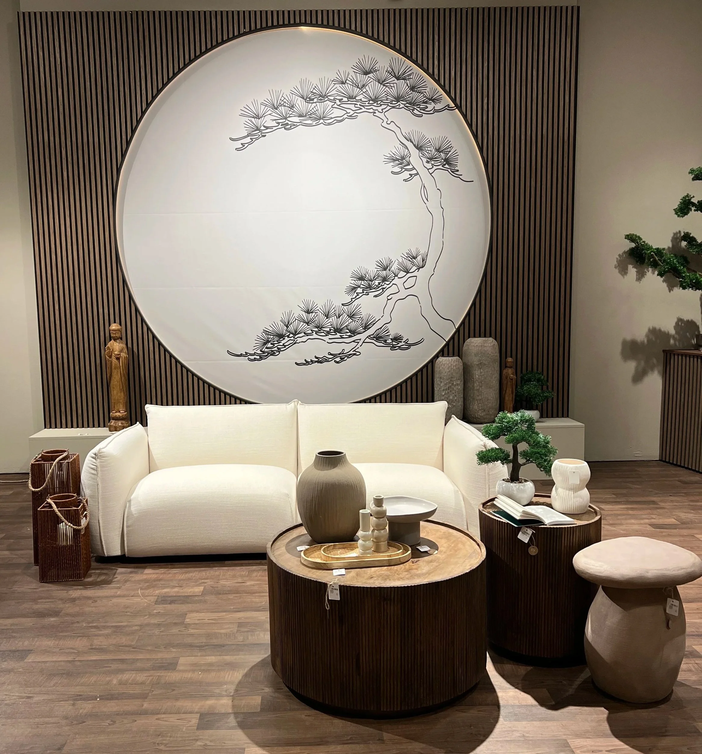 Innenraum mit weißem Sofa, runden Tischen, Dekorationsvasen und Kunstdekorationen im asiatischen Stil.