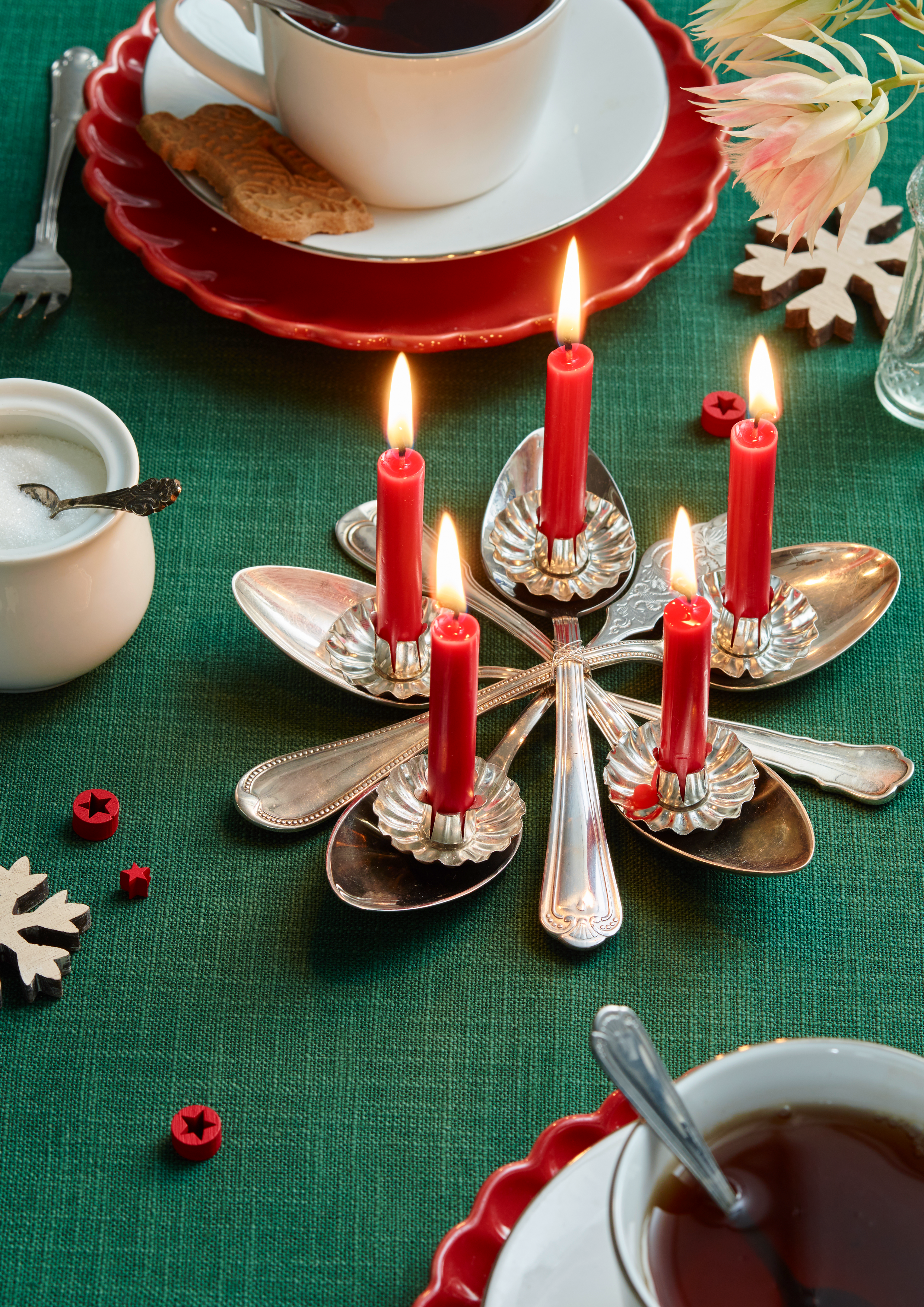 Weihnachtstisch mit Kerzen, Kaffee, Keksen, Blumen und Dekorationen, festliche Atmosphäre