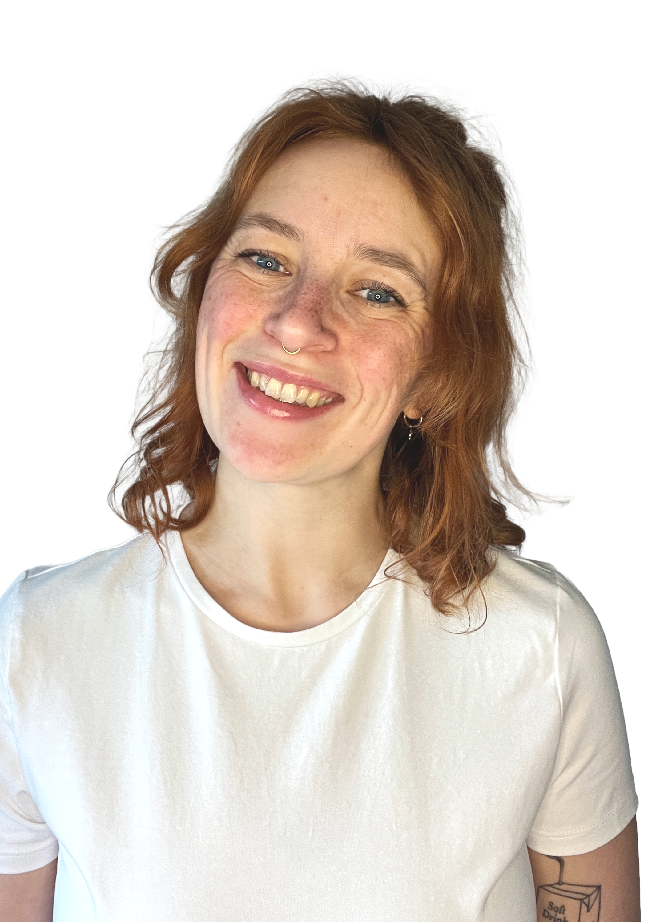 Lächelnde Frau mit roten Haaren, Piercings, weißen T-Shirt und Tattoo auf dem Oberarm, vor neutralem Hintergrund.