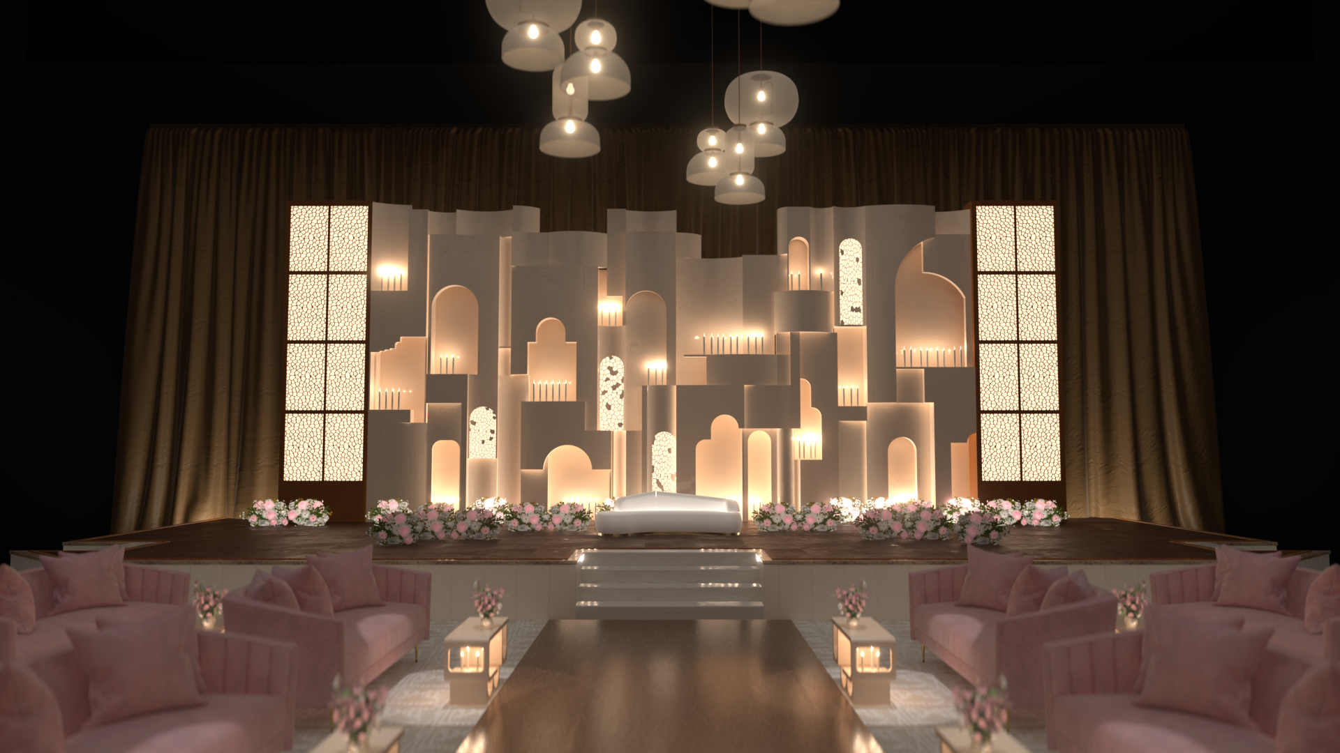 Elegant stage with white backdrop, soft lighting, pink sofas with cushions, floral arrangements, and hanging ceiling lights, set up for a wedding or special event.
