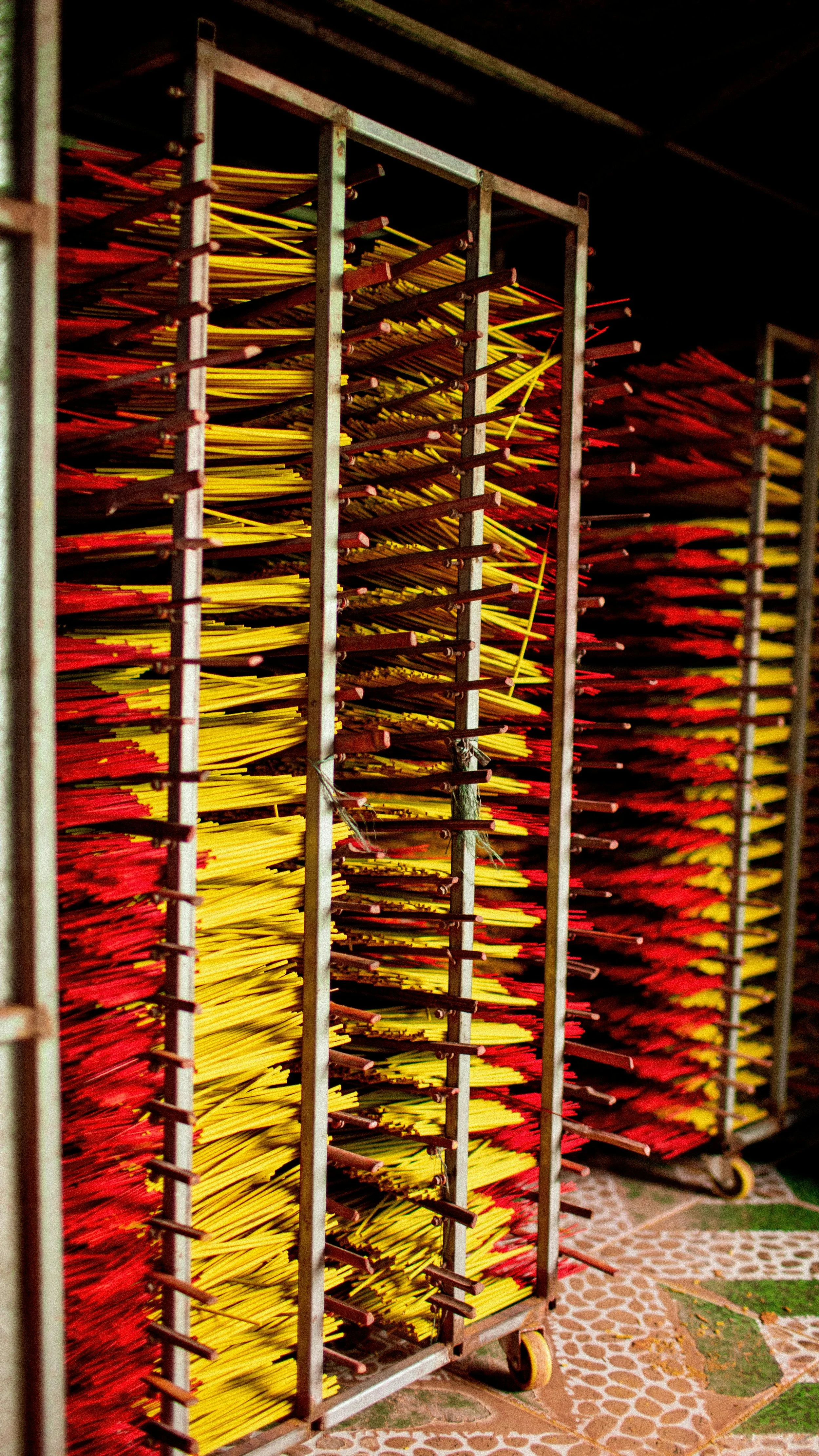 Metal racks filled with yellow and red fabric flags or banners stacked vertically.